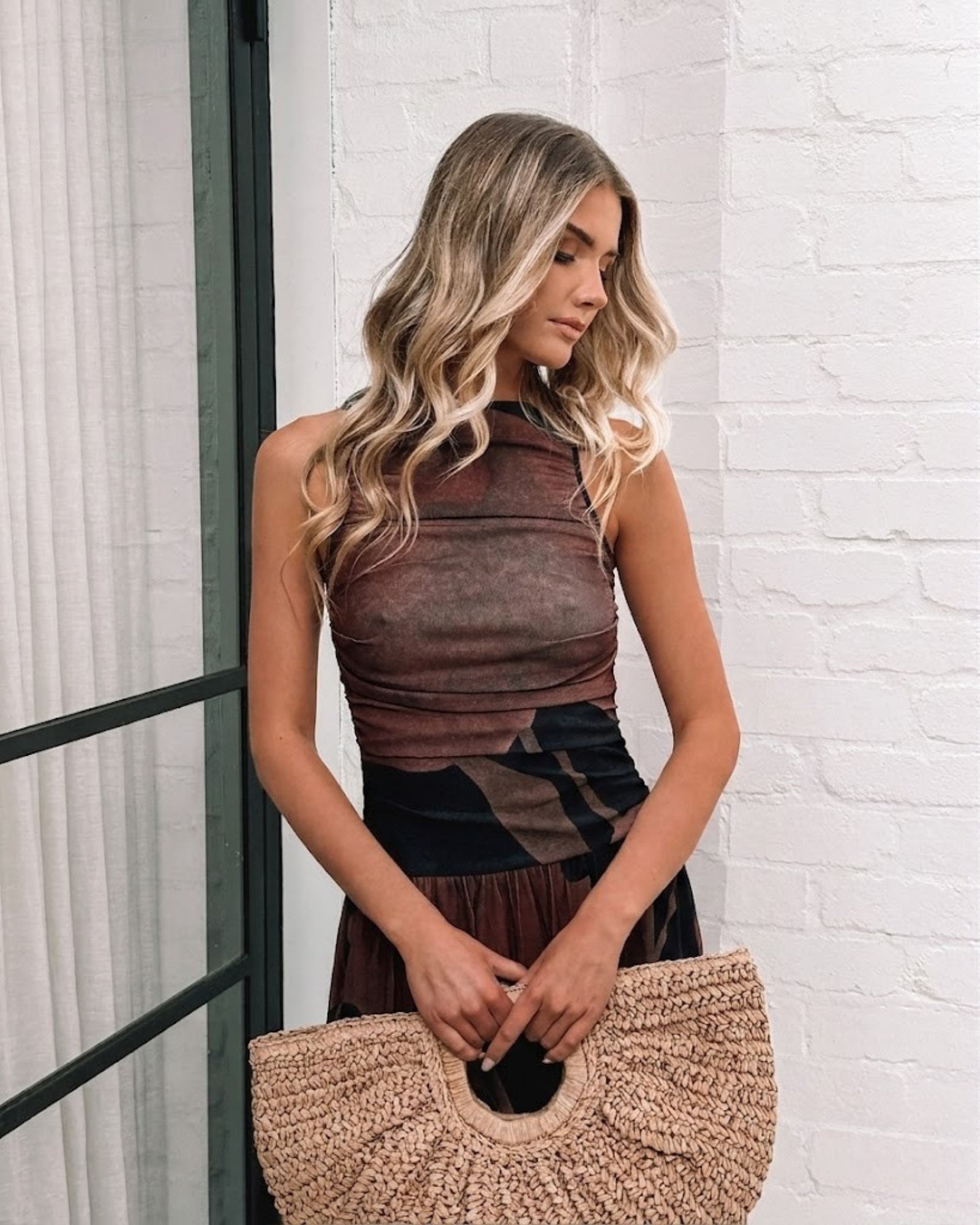 Women's flowy black choc print midi dress styled for evening by Esther & Co