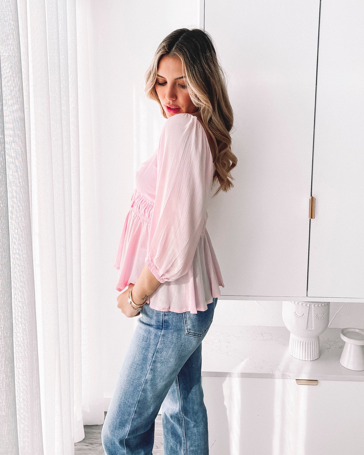Women's feminine pink blouse with bubble sleeves and flowy peplum silhouette by Esther & Co