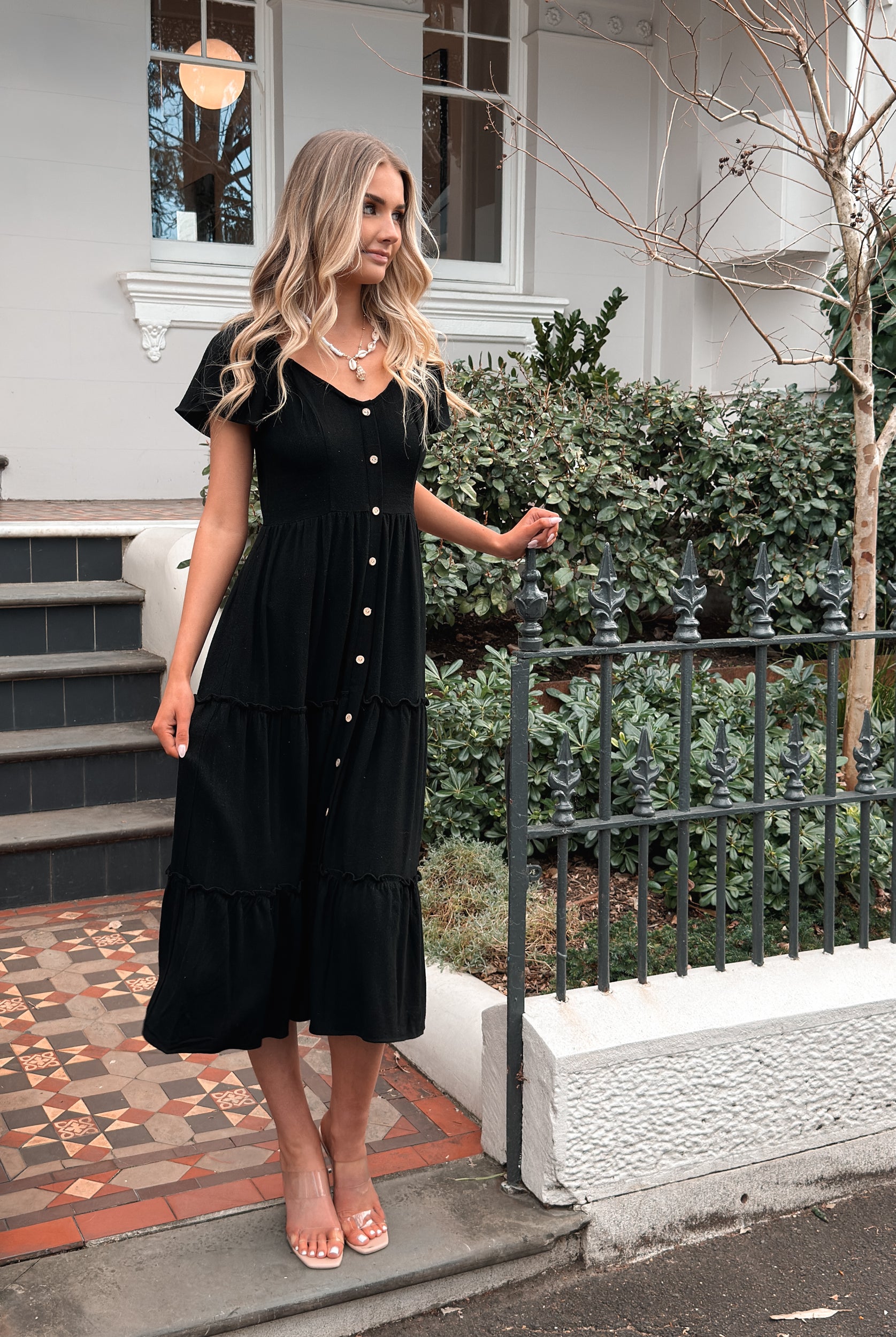 Women wearing the Celie Dress in Black, a relaxed linen midi dress with V-neckline and button-up front