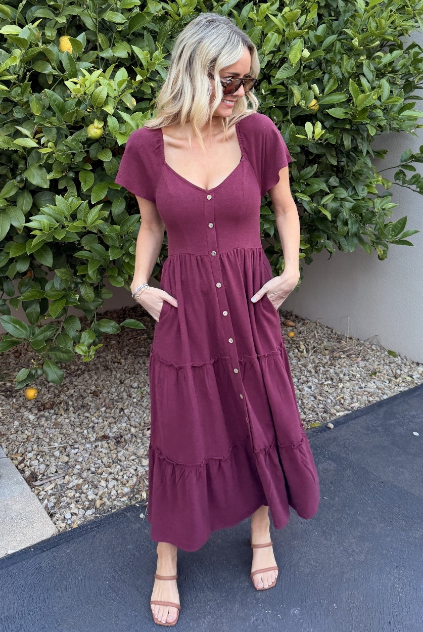 Women wearing the Celie Dress in Bordeaux, a relaxed linen midi dress with V-neckline and button-up front