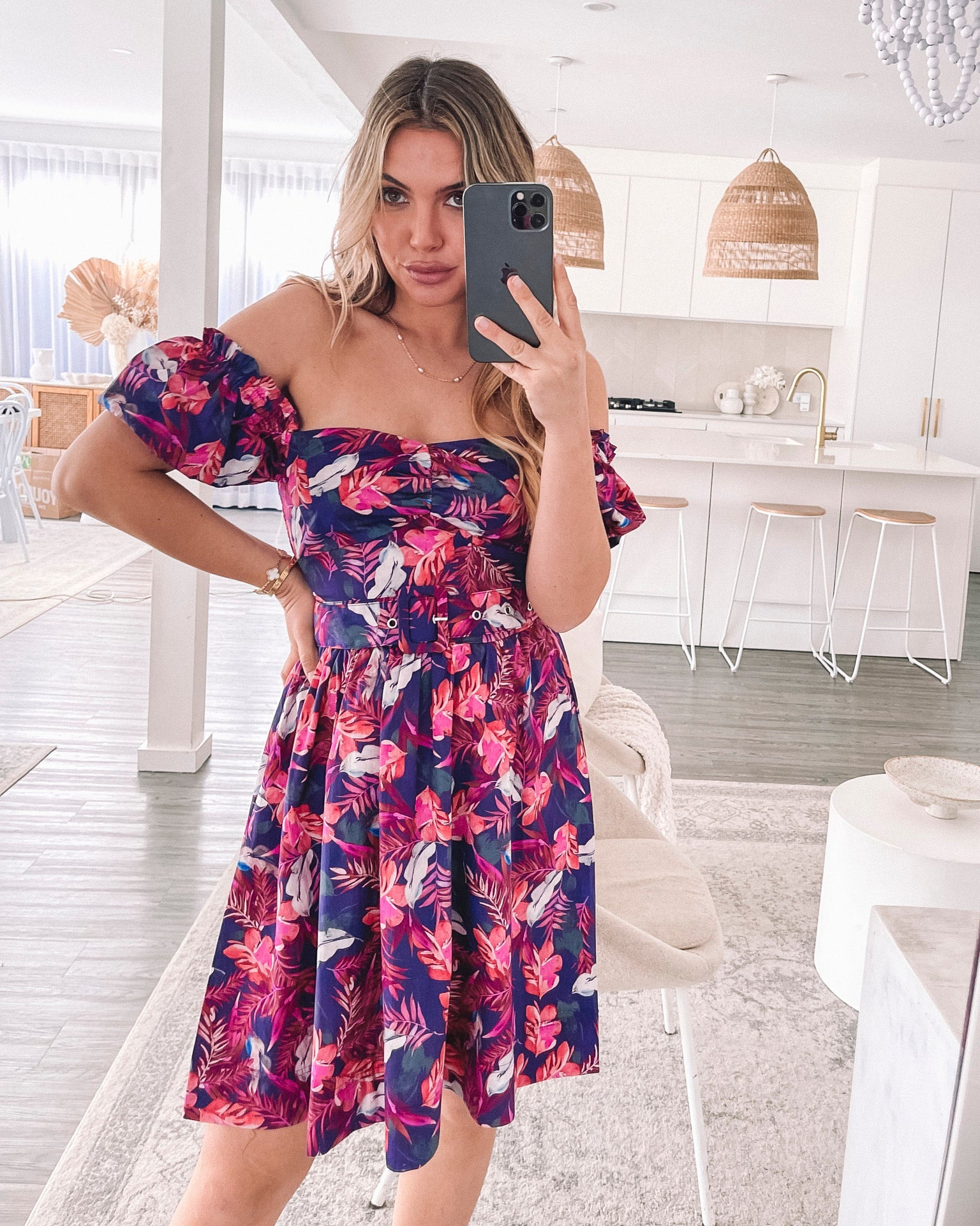 Women's flowy purple print mini dress styled for a garden party by Esther & Co