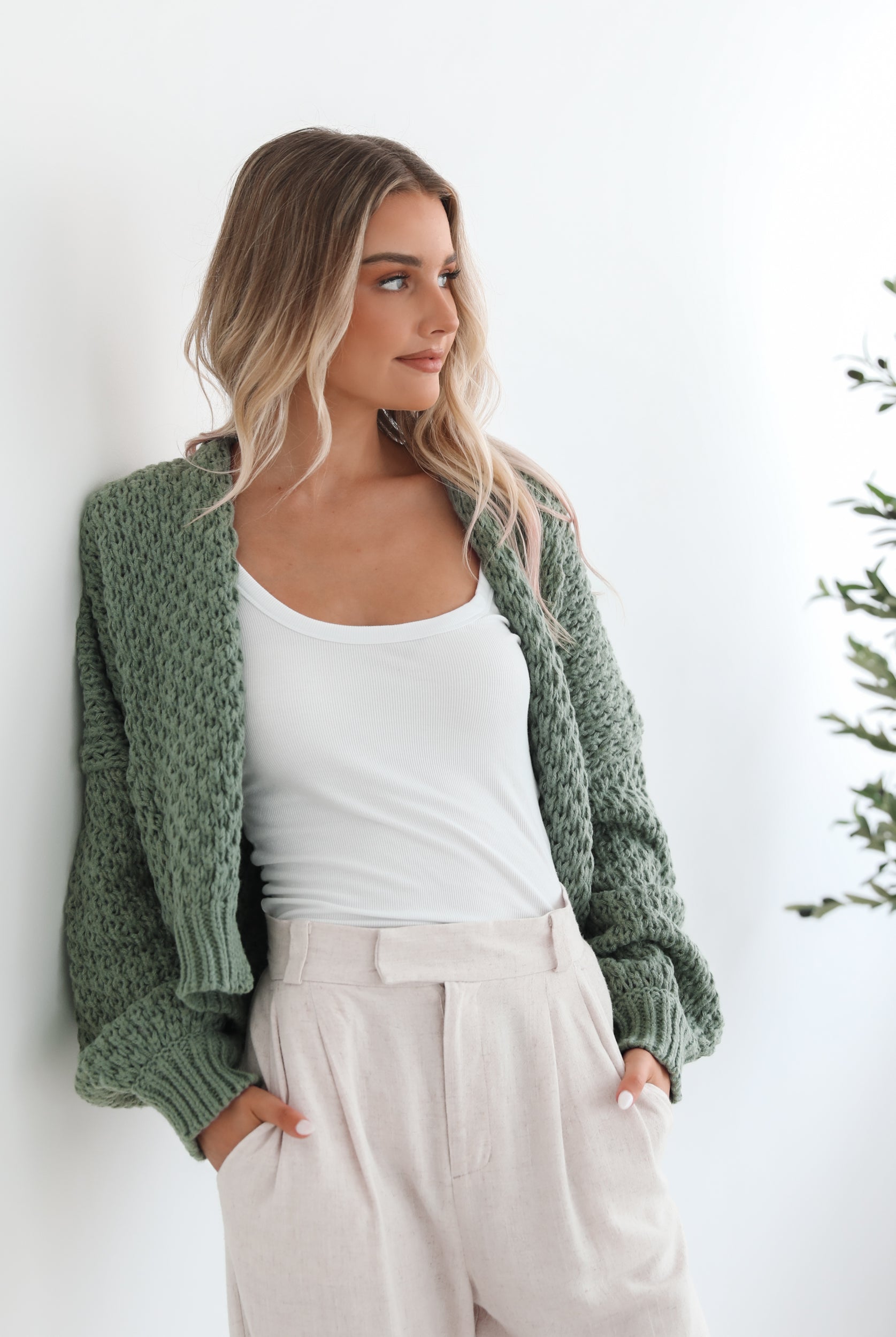 Model wearing the Dorine Forest Green Cardigan over a slip dress for an elevated brunch look