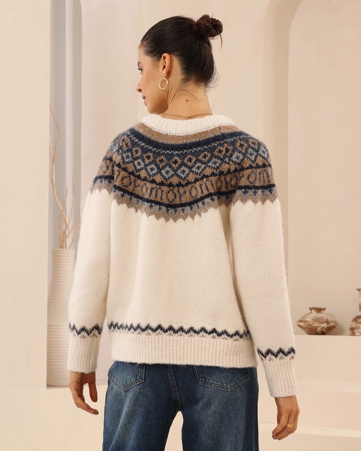 Woman wearing a patterned sweater with a neutral background