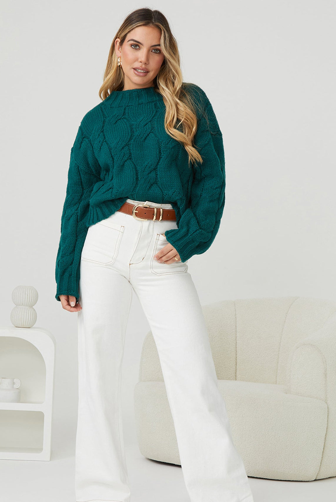 Side view of the Hadi Knit in Dark Green showing the long sleeves and relaxed fit