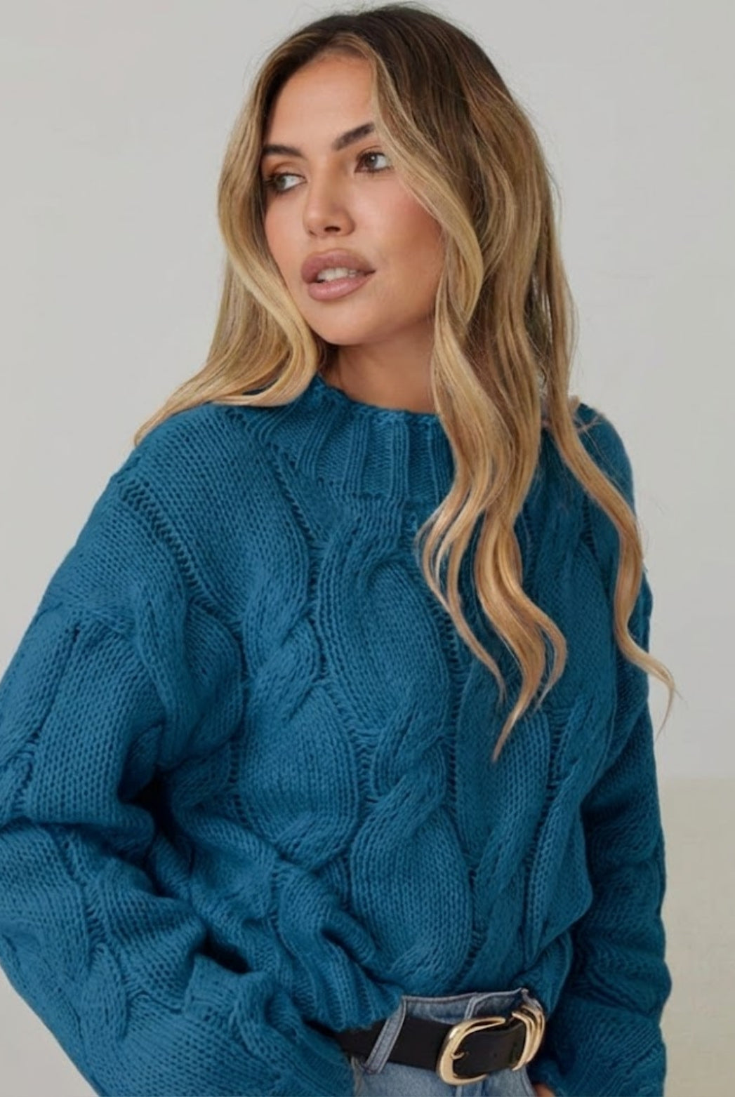 Women wearing the Hadi Knit in Teal, a cosy acrylic women's jumper in striking teal with high round neckline
