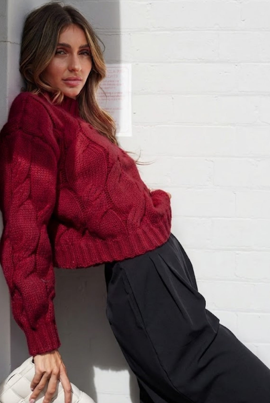 Side view of the Hadi Knit in Wine showing the long sleeves and relaxed fit