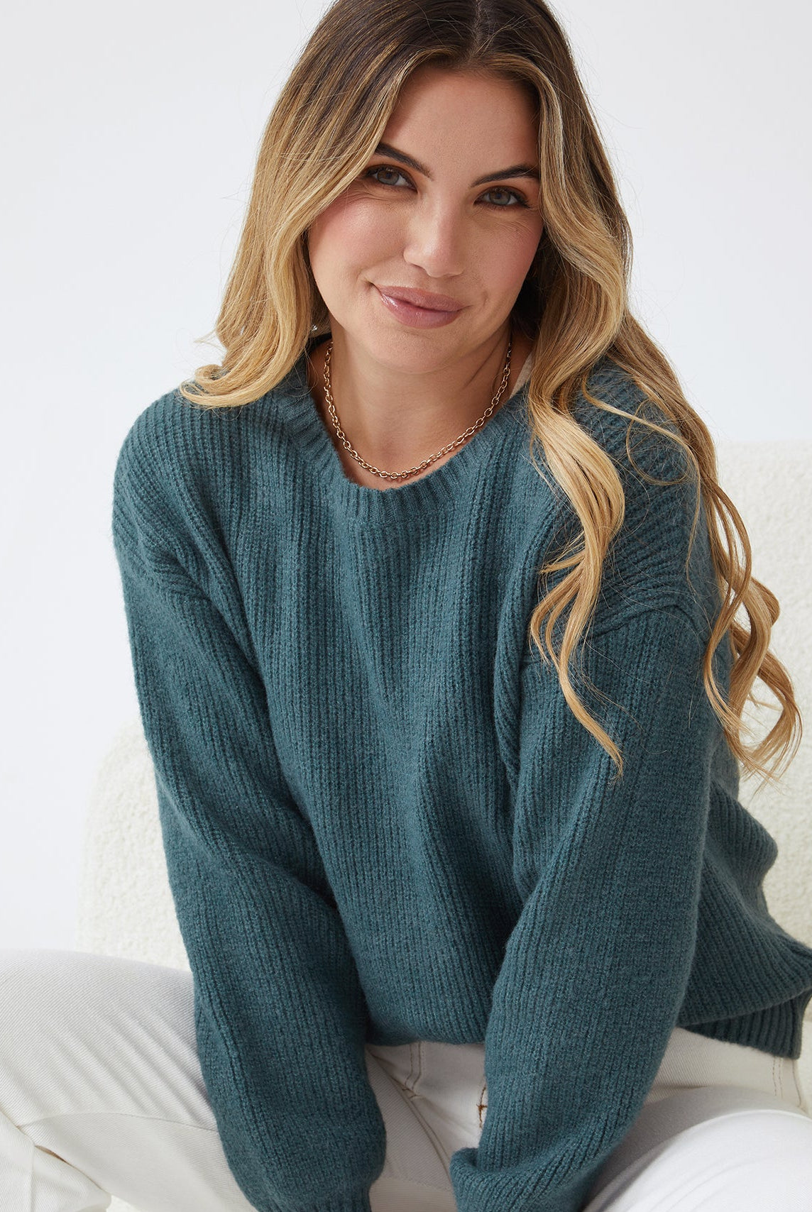 Women wearing the Harvie Knit in Petrol, a soft wool blend jumper in rich deep teal with round neckline and long sleeves