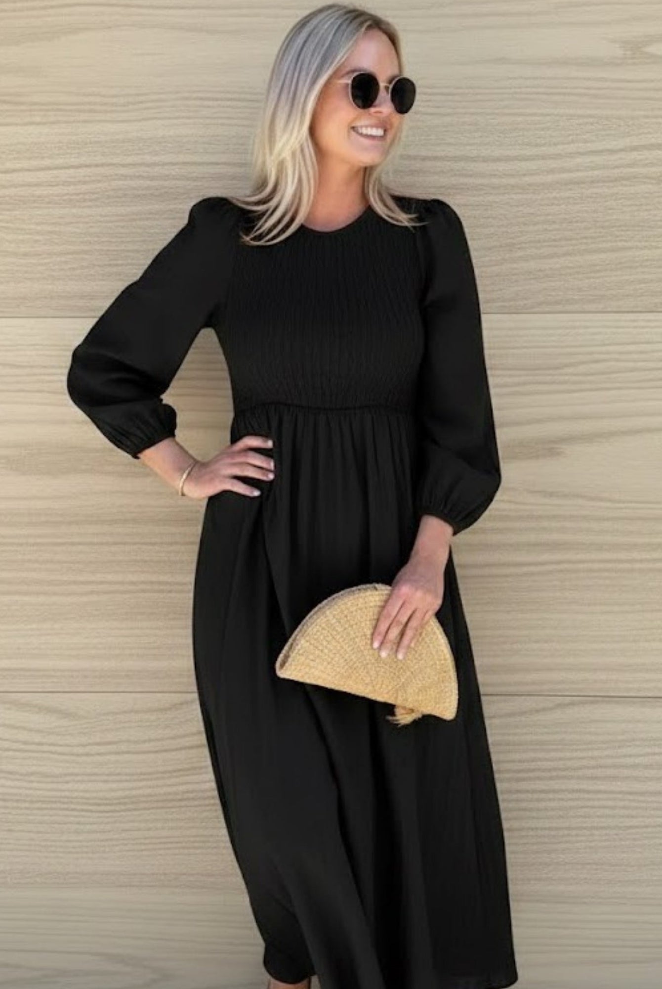 Women wearing the Iolana Dress in Black Long Sleeve, a cotton midi dress with round neckline and smocked bodice