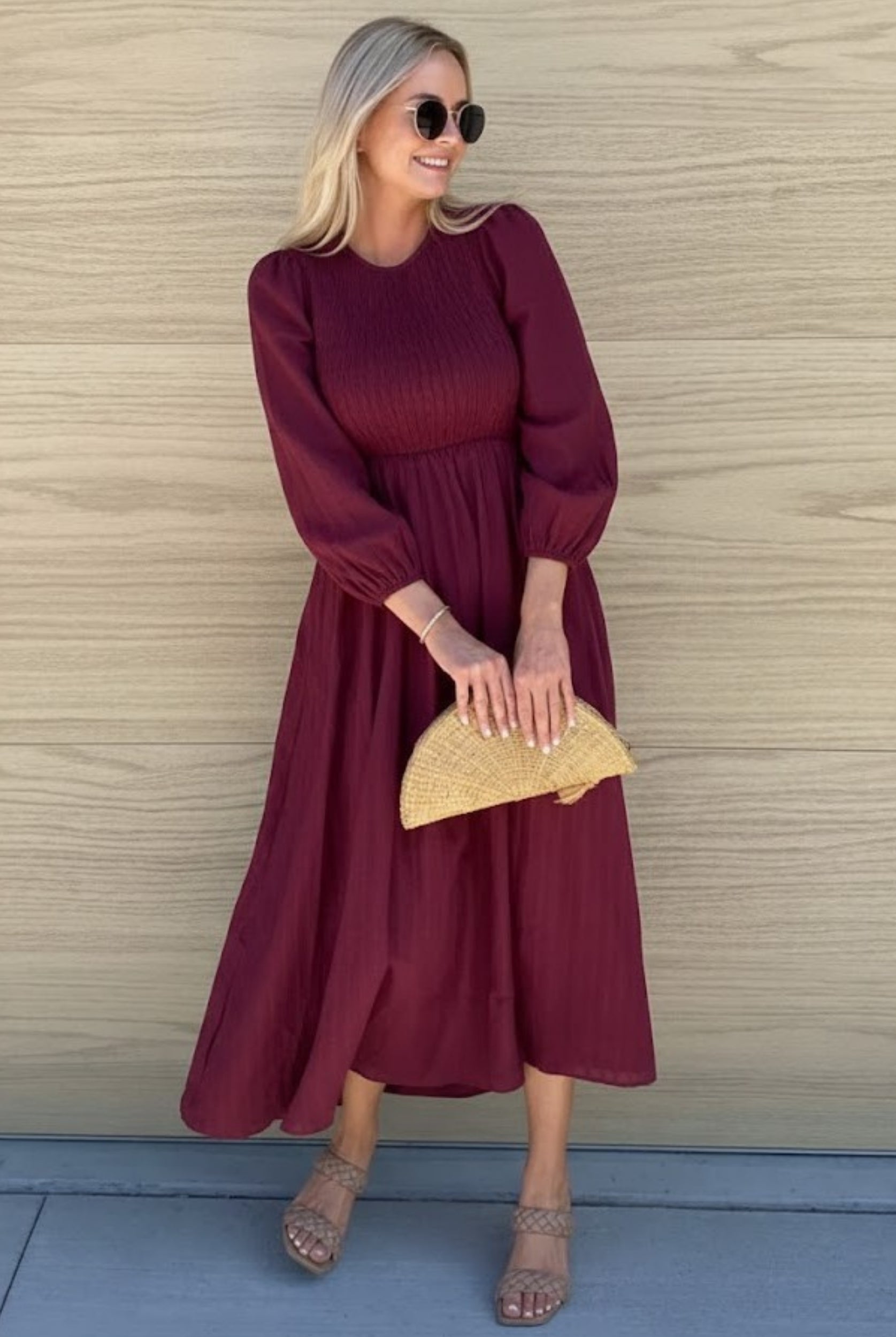 Women wearing the Iolana Dress in Wine Long Sleeve, a cotton midi dress with round neckline and smocked bodice in rich wine