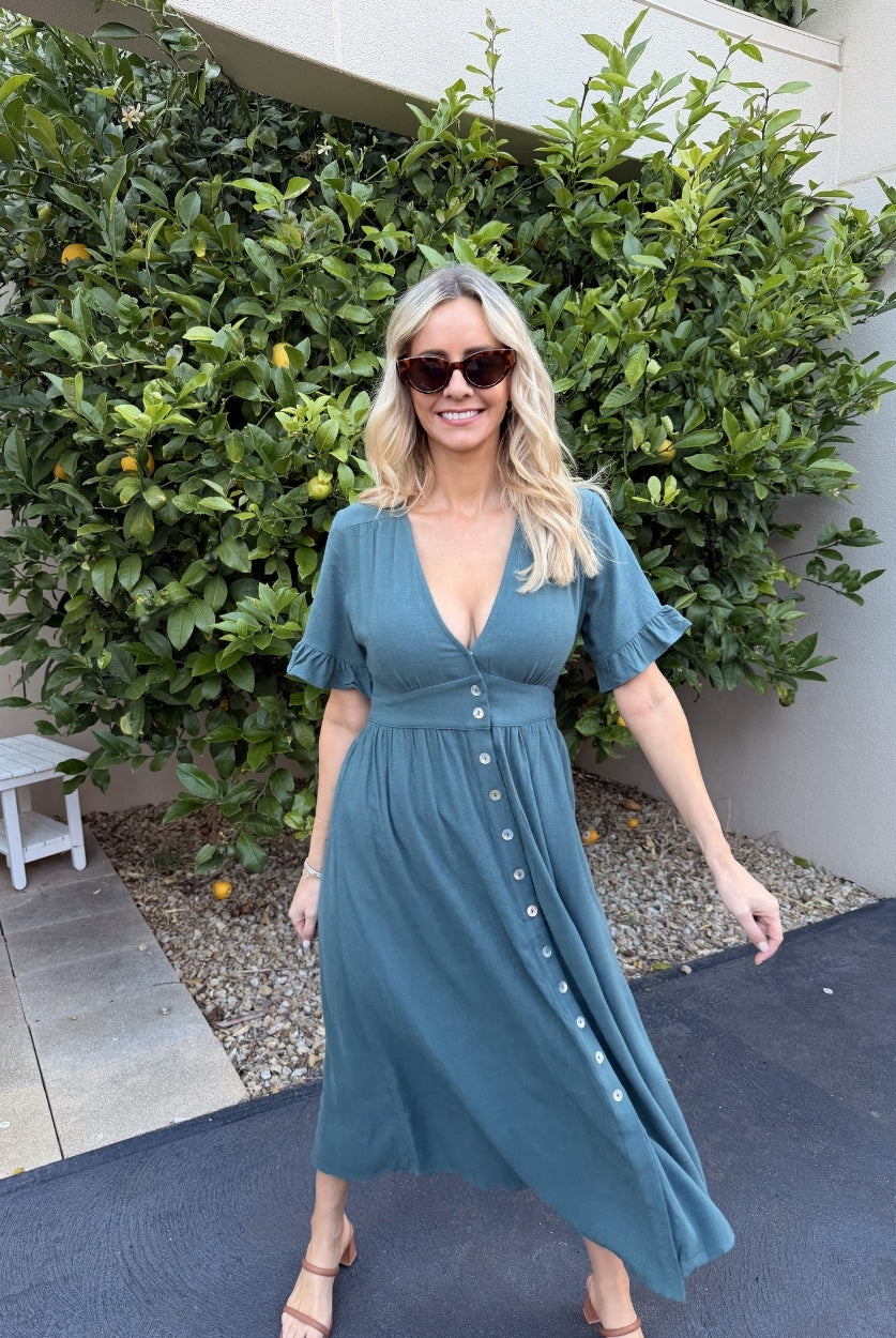 Side view of the Korbela Dress in Deep Green showing the relaxed A-line silhouette and midi length