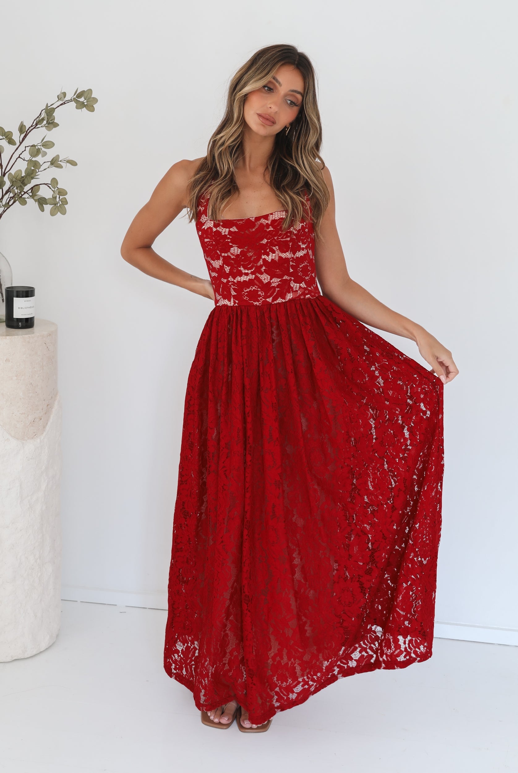 A woman wearing a red maxi dress with a halter neckline.