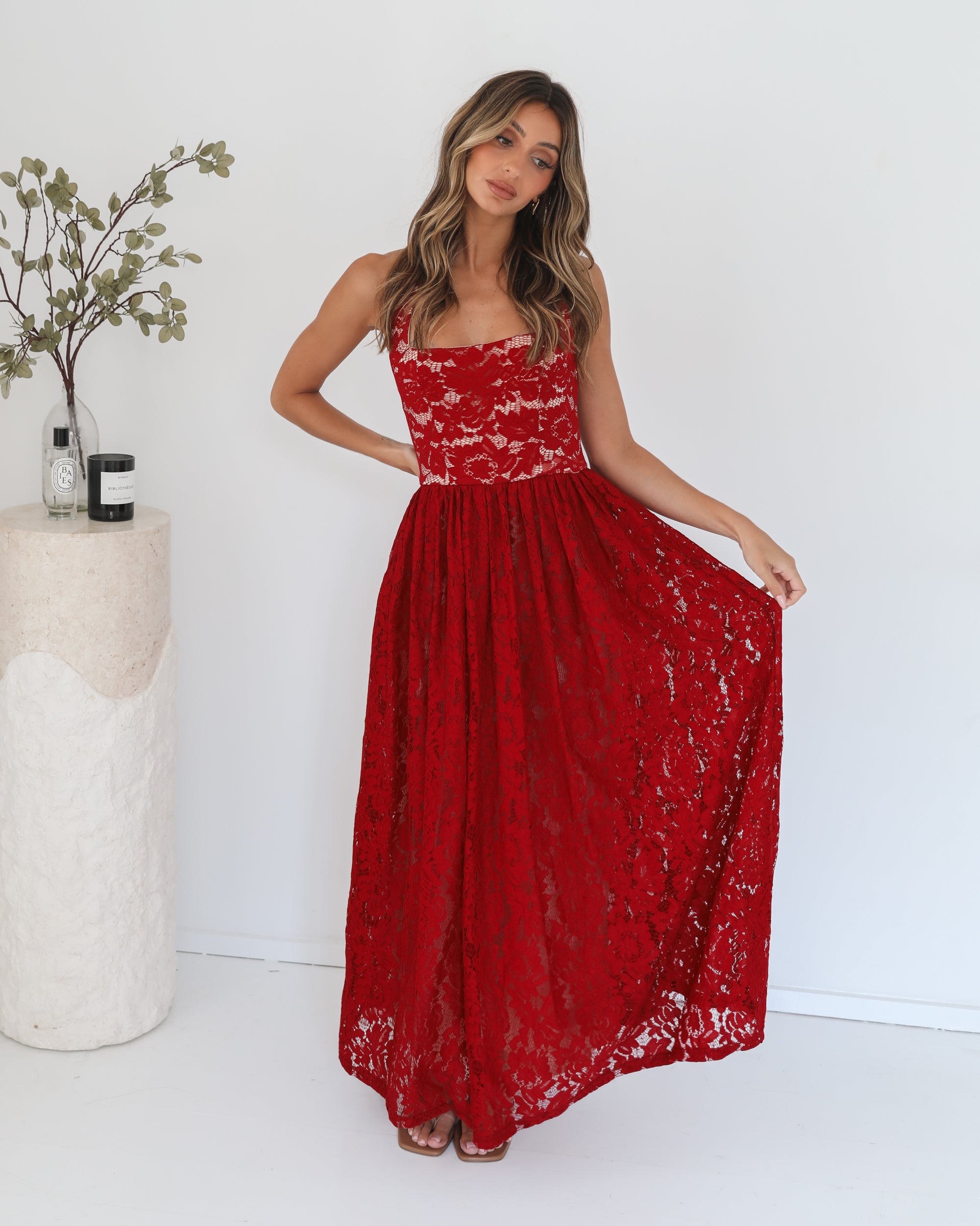 A woman wearing a red maxi dress with a halter neckline.