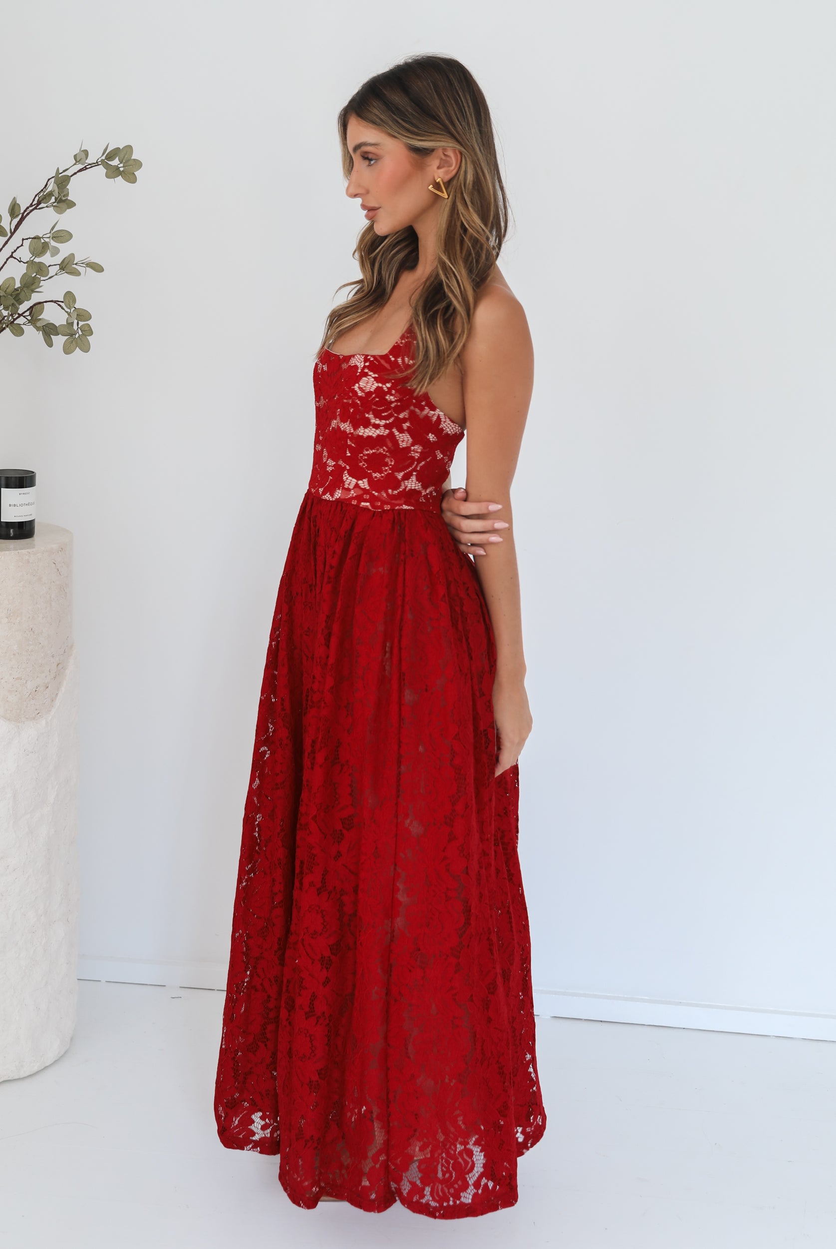 A woman wearing a red maxi dress with a halter neckline.