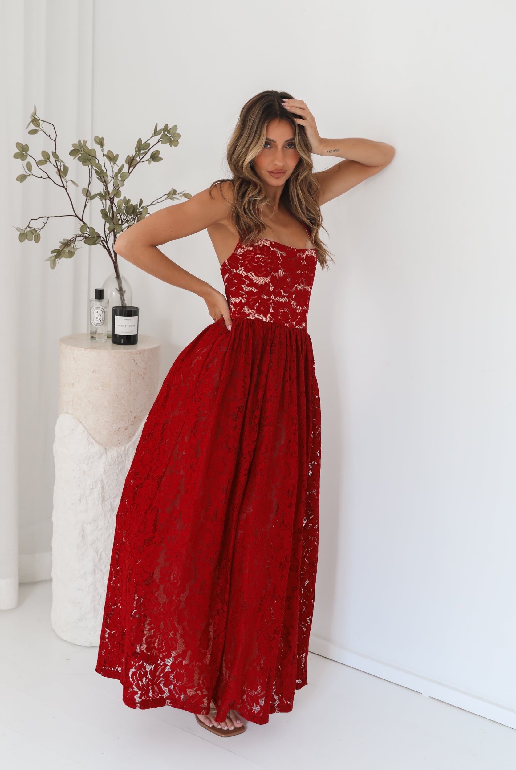 A woman wearing a red maxi dress with a halter neckline.