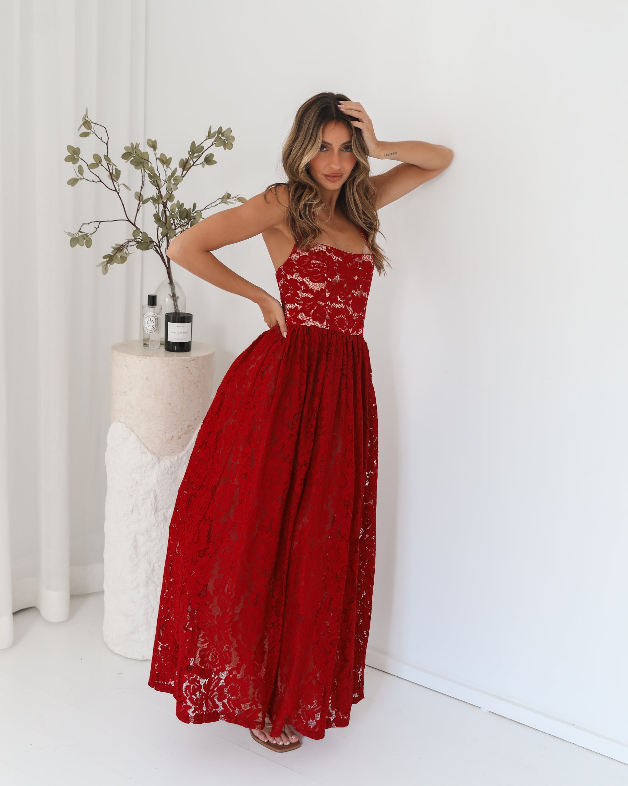 A woman wearing a red maxi dress with a halter neckline.