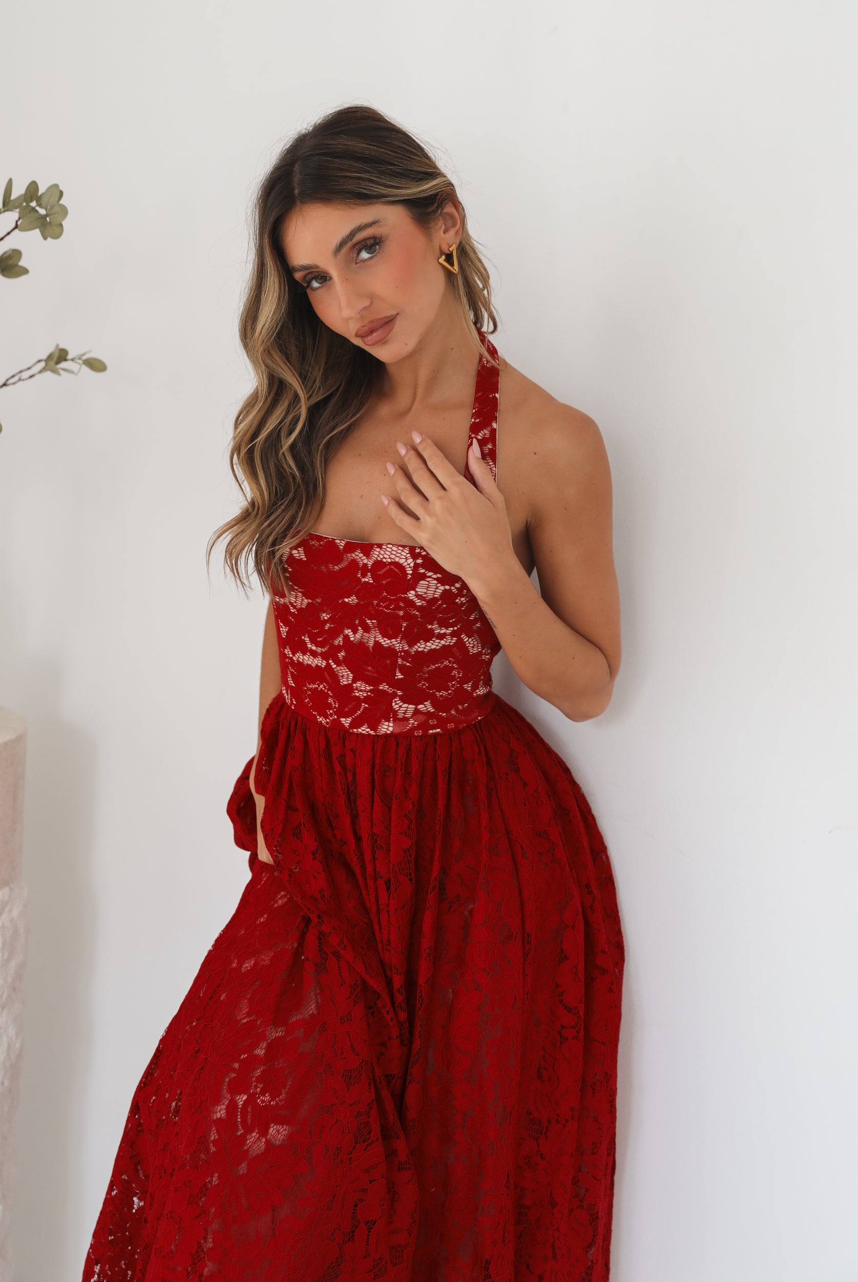 A woman wearing a red maxi dress with a halter neckline.