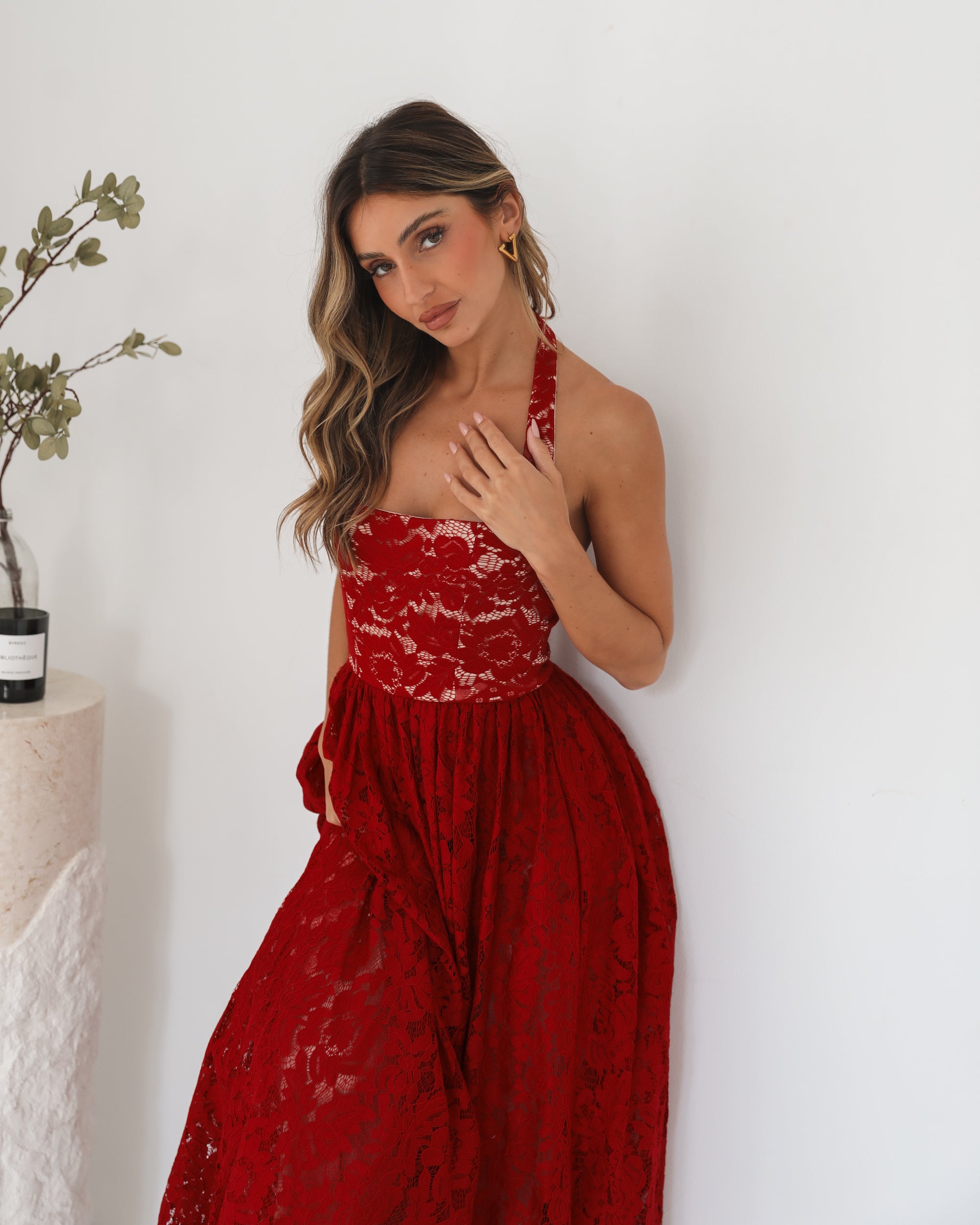 A woman wearing a red maxi dress with a halter neckline.