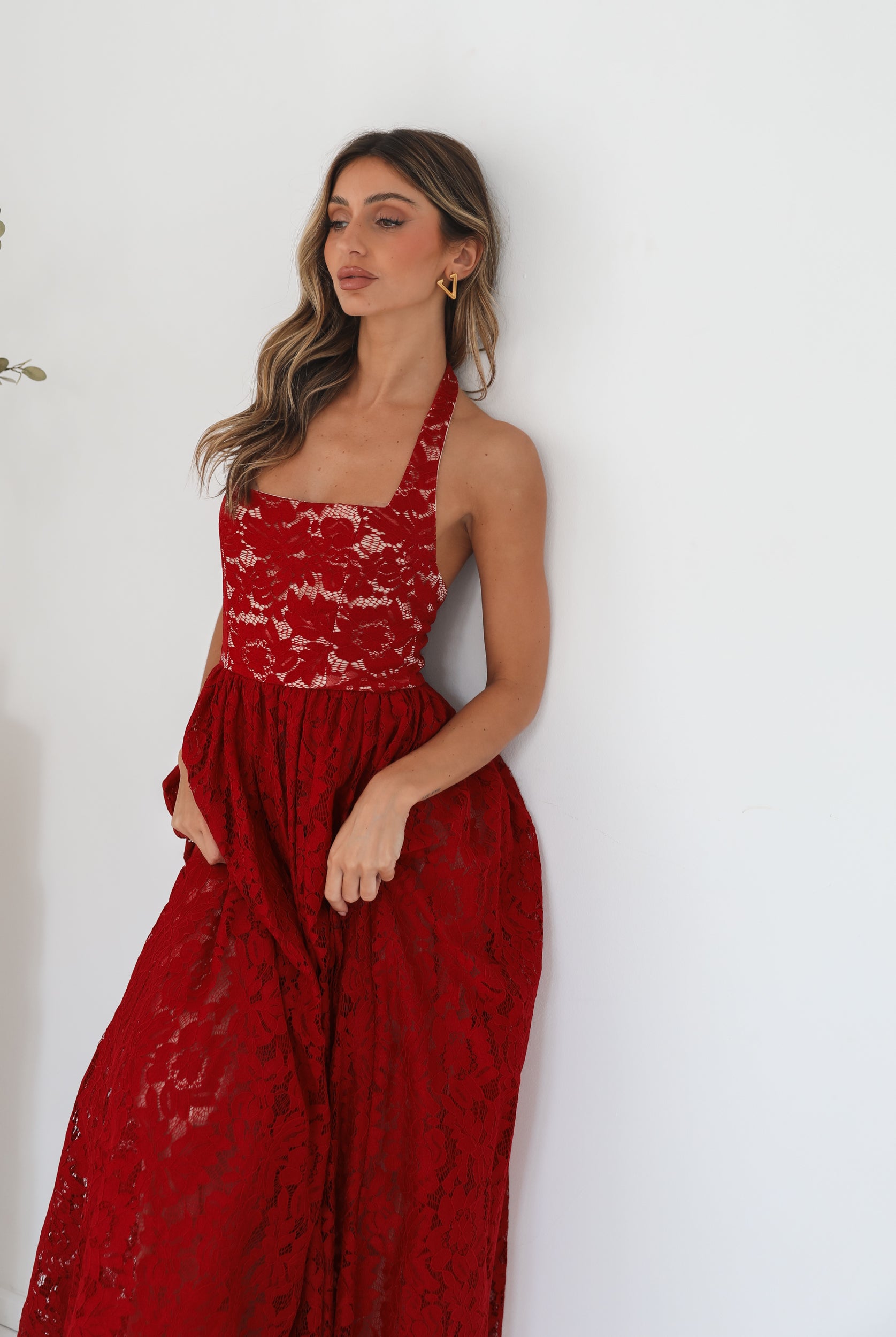 A woman wearing a red maxi dress with a halter neckline.