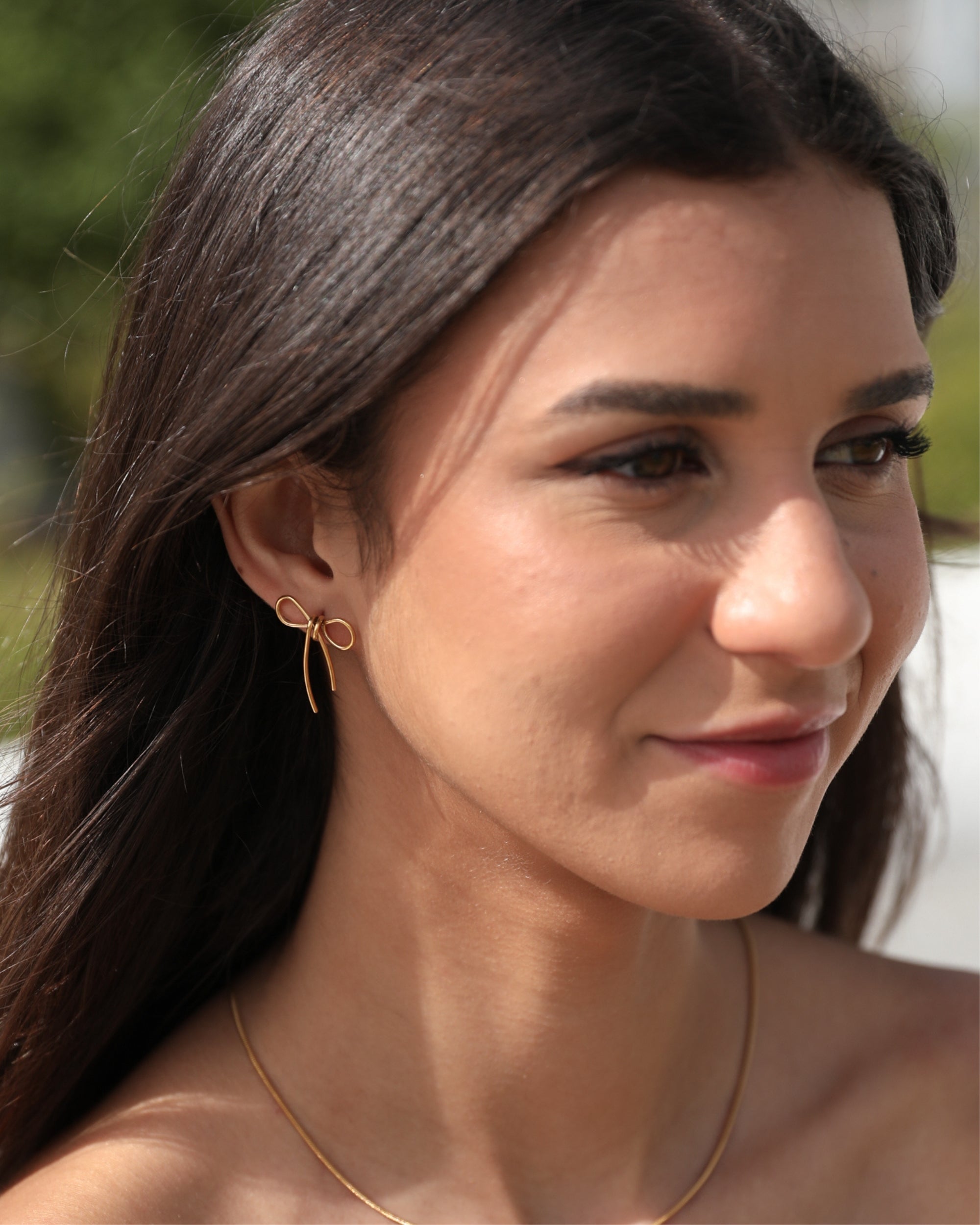 Woman wearing gold earrings and necklace outdoors