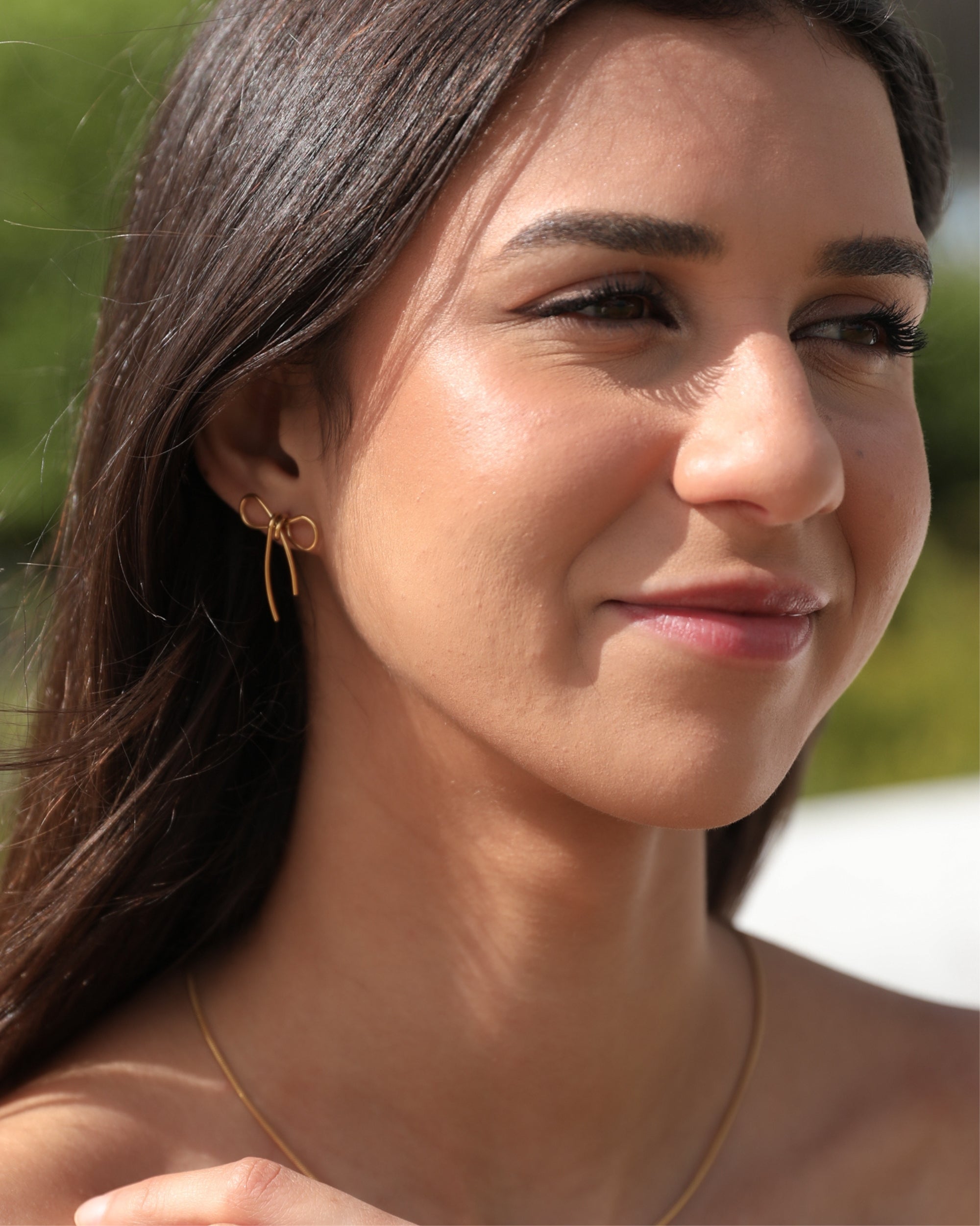 Woman wearing gold earrings and necklace outdoors