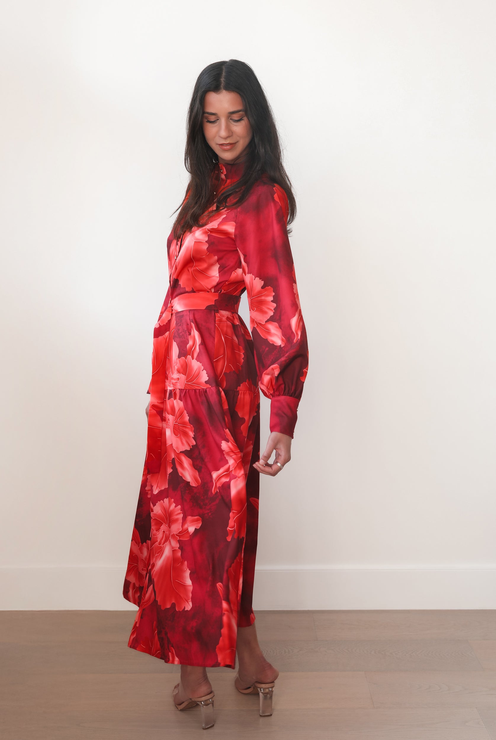 Woman wearing a red floral dress against a white background