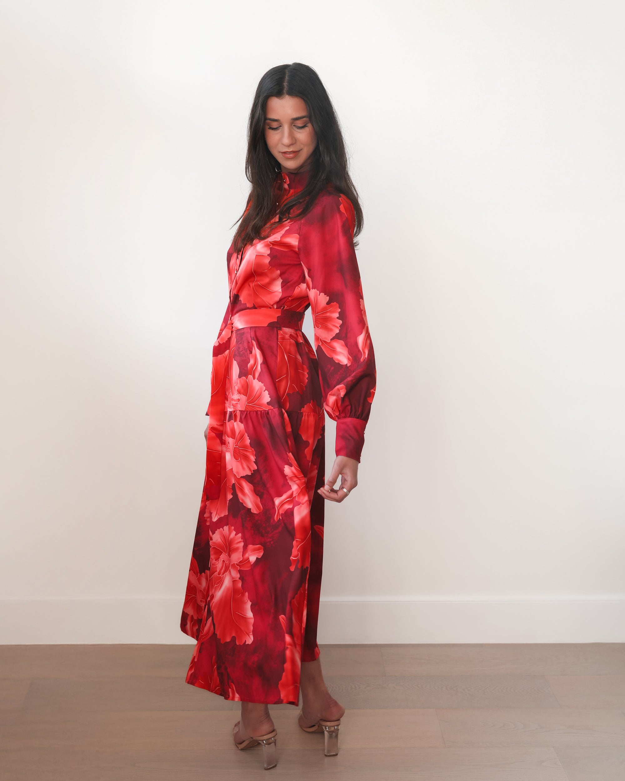 Woman wearing a red floral dress against a white background