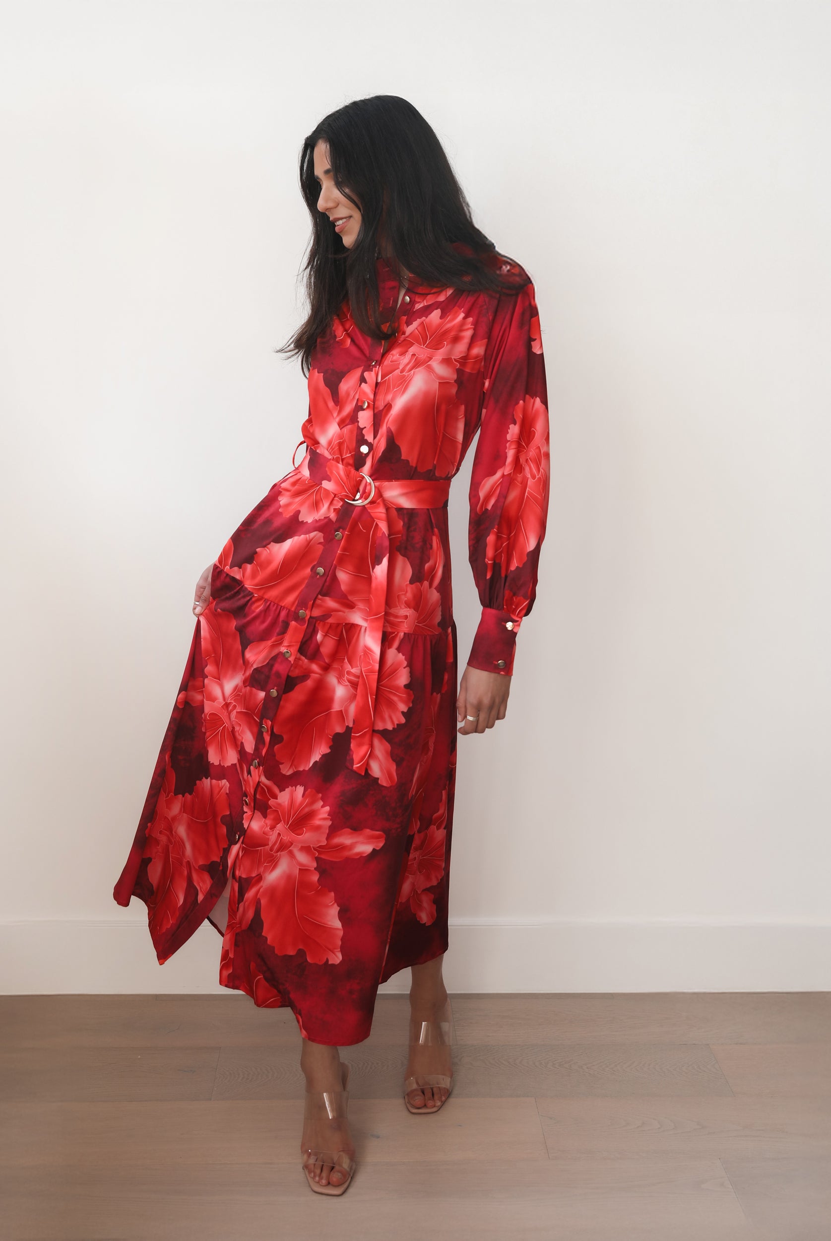 Woman wearing a red floral dress against a white background