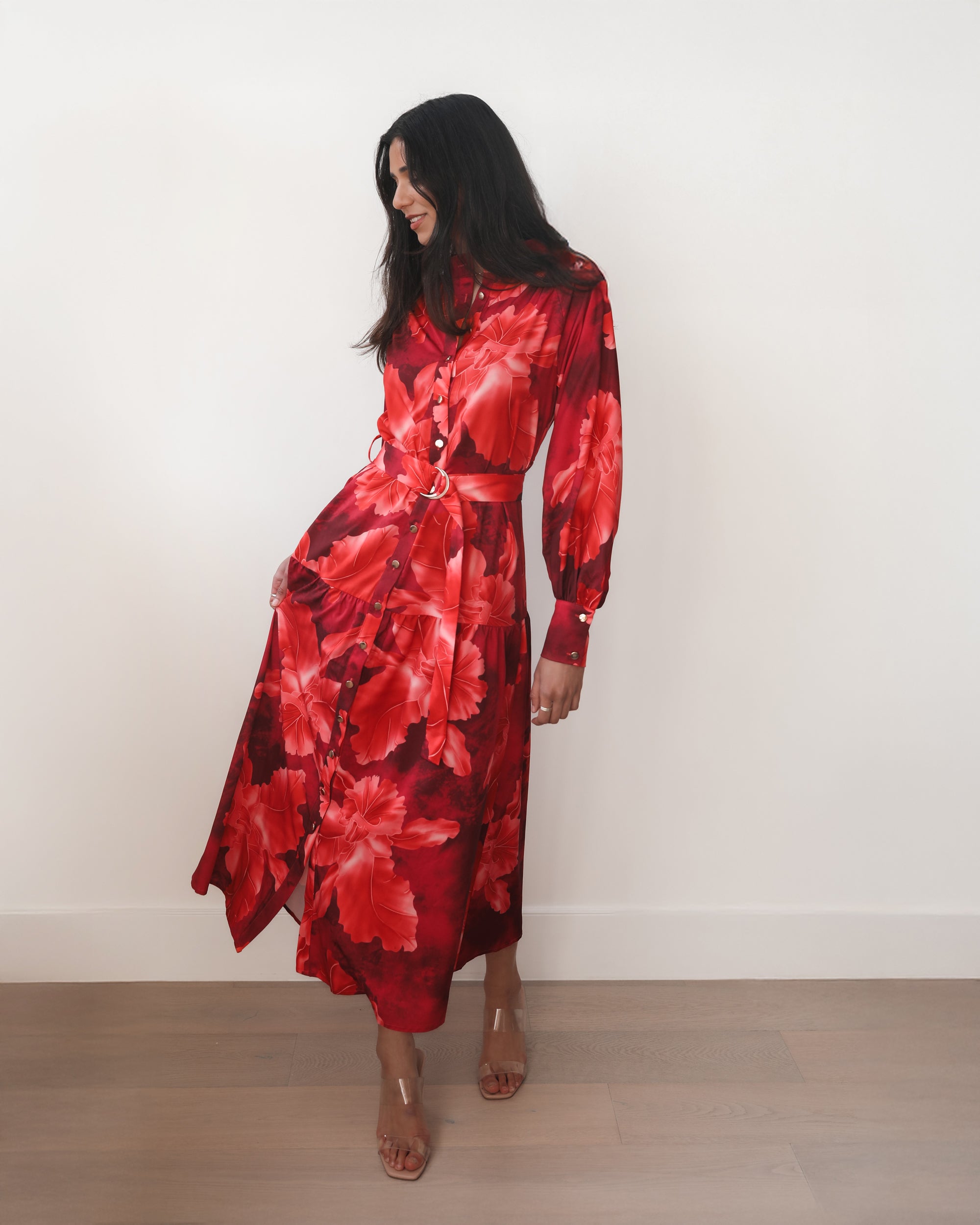 Woman wearing a red floral dress against a white background