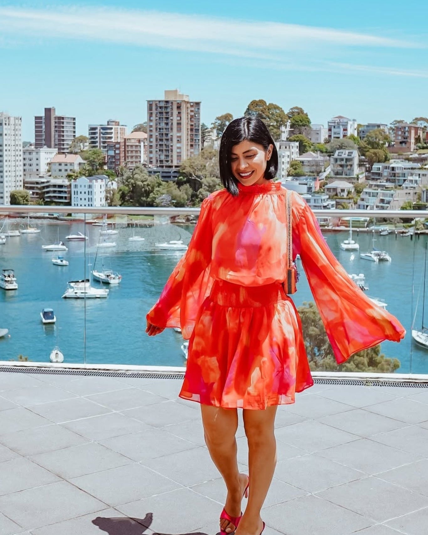 Influencer wearing the Daenerys Orange Print Mini Dress from Esther and Co