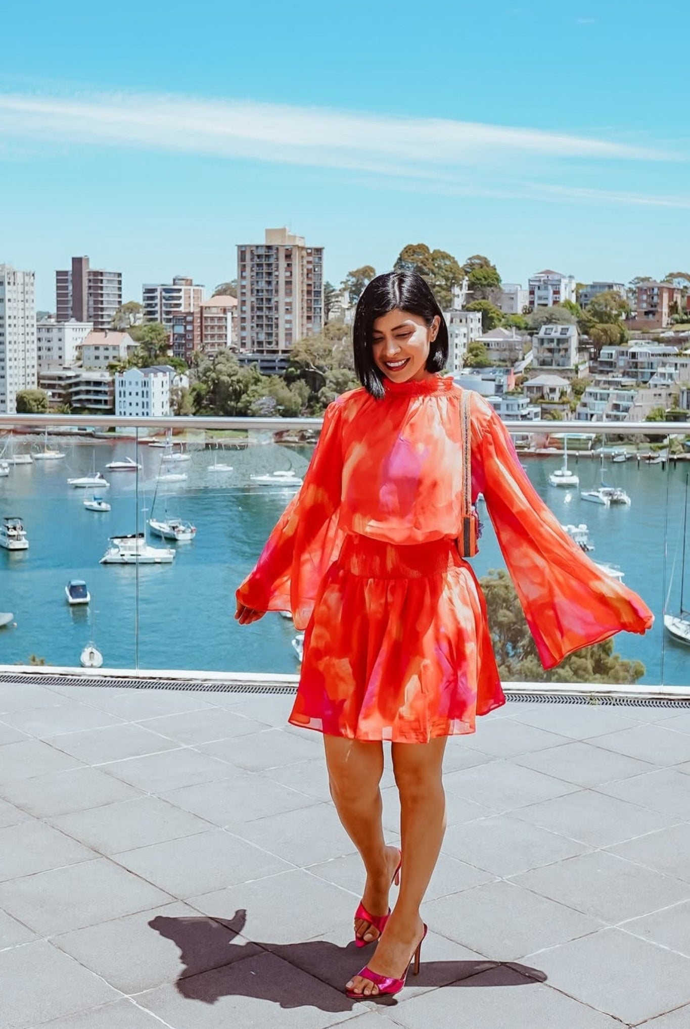 Influencer wearing the Daenerys Orange Print Mini Dress from Esther and Co