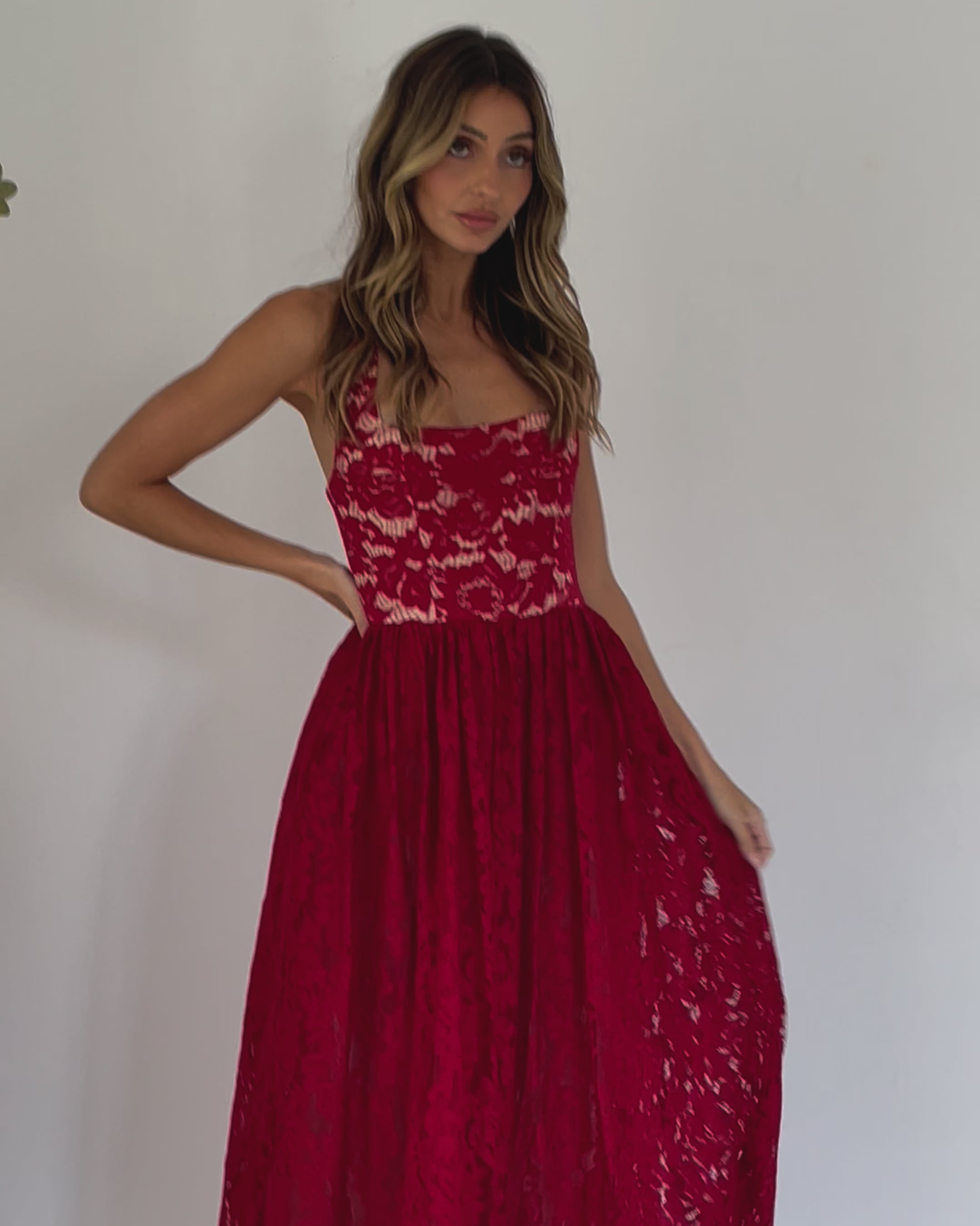 A woman wearing a red maxi dress with a halter neckline.