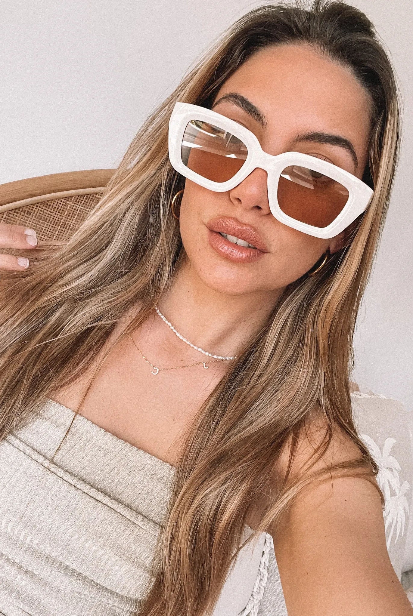 A pair of beige sunglasses displayed on a surface.