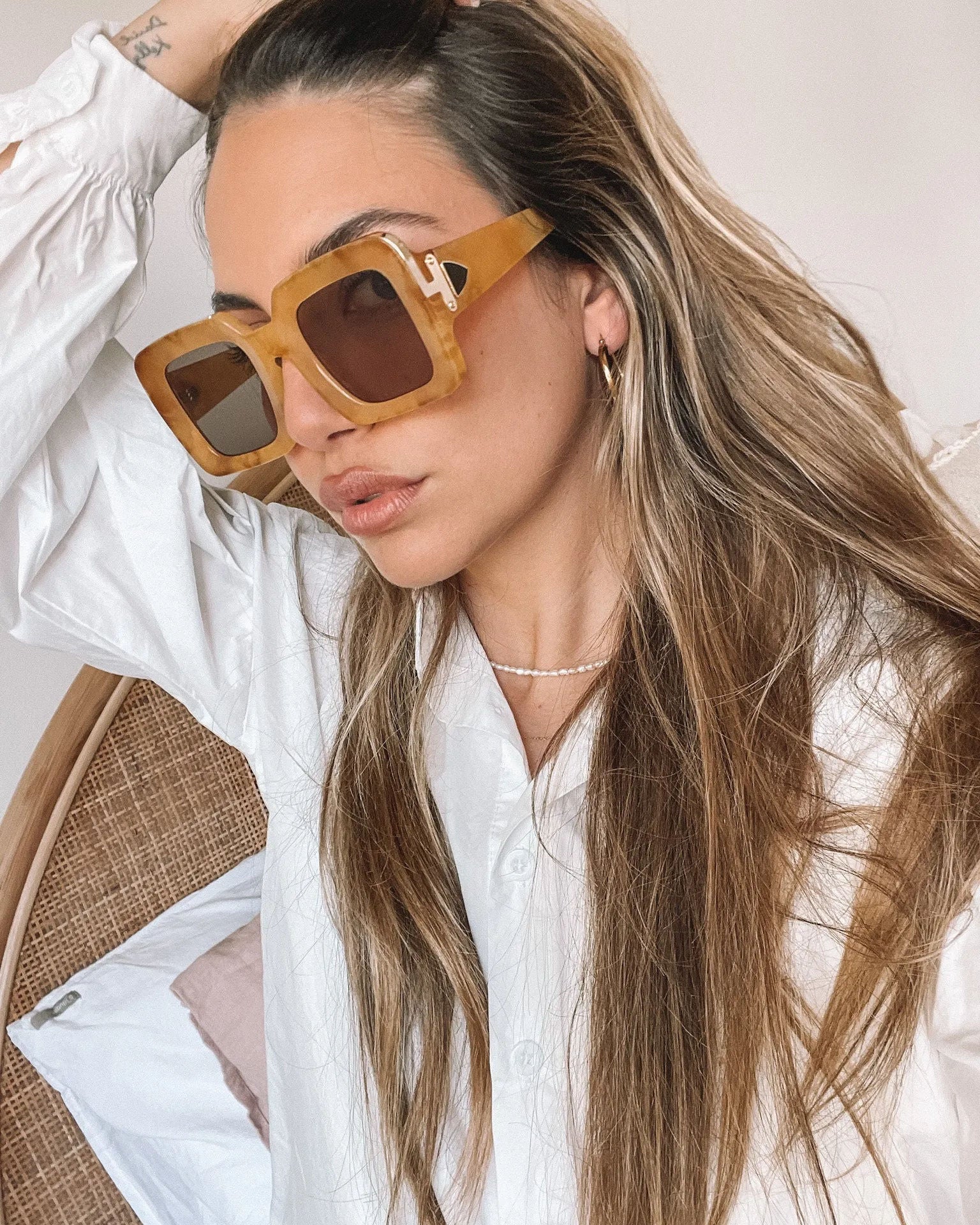 A pair of sunglasses with a tan frame displayed on a surface.