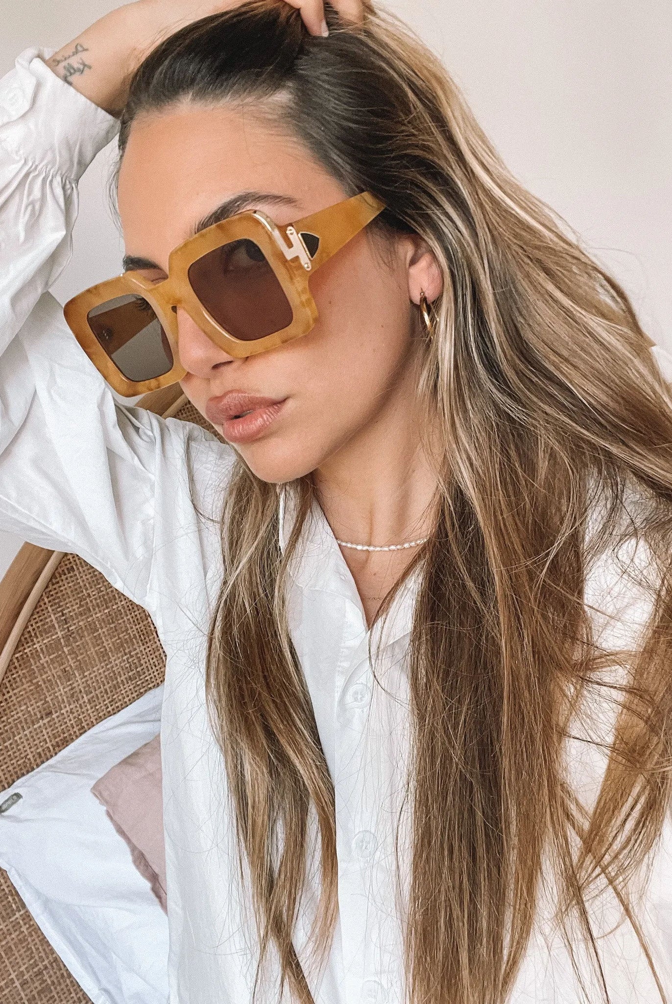 A pair of sunglasses with a tan frame displayed on a surface.