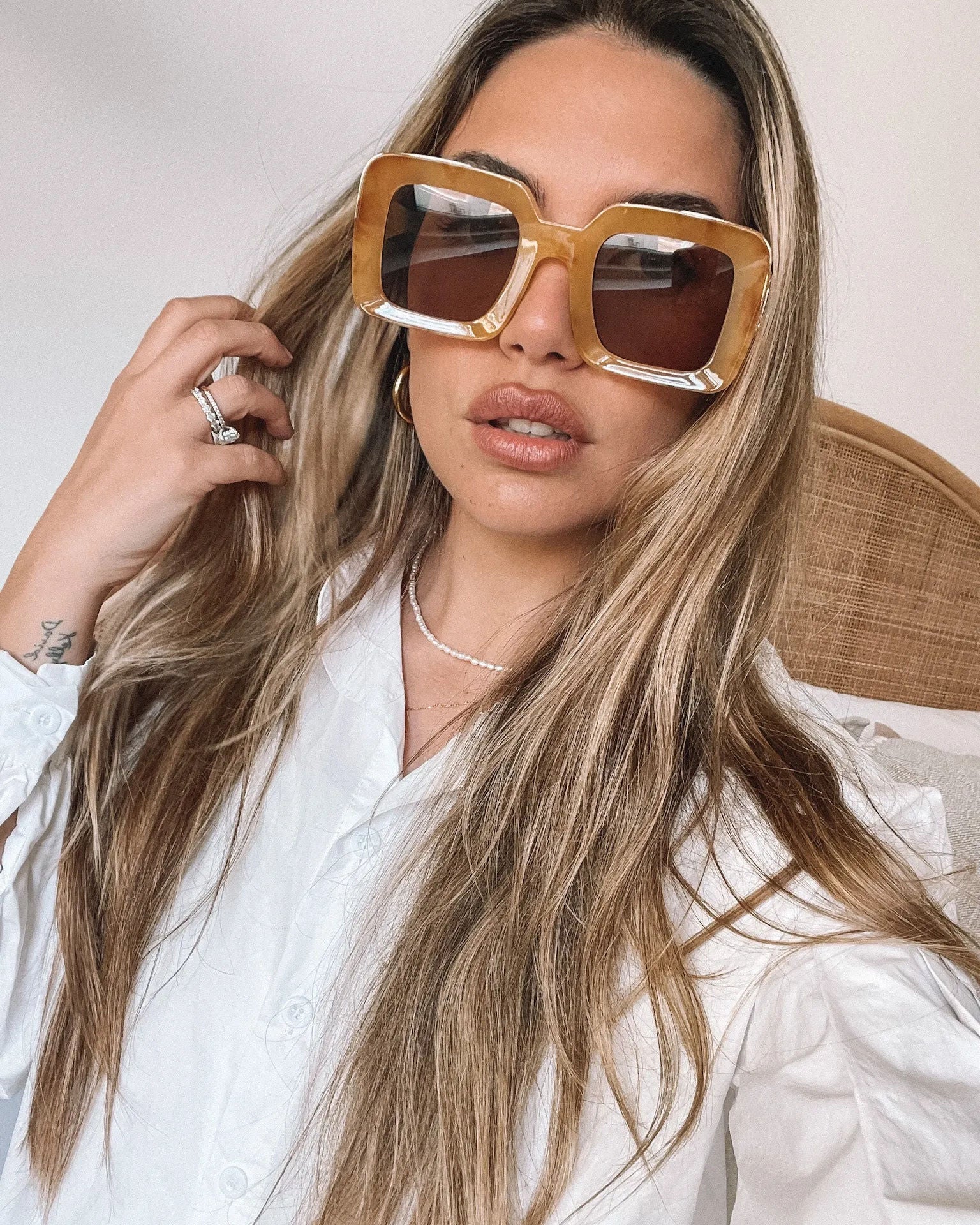 A pair of sunglasses with a tan frame displayed on a surface.