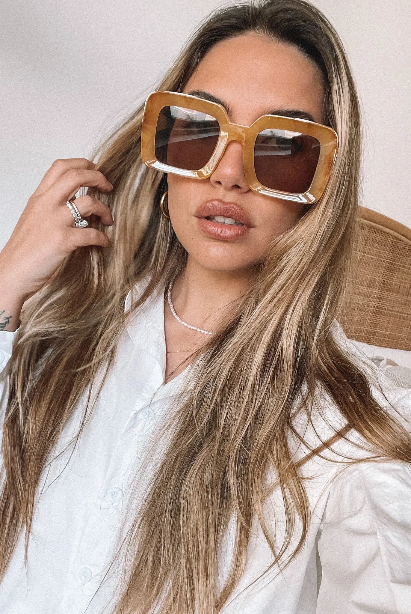 A pair of sunglasses with a tan frame displayed on a surface.