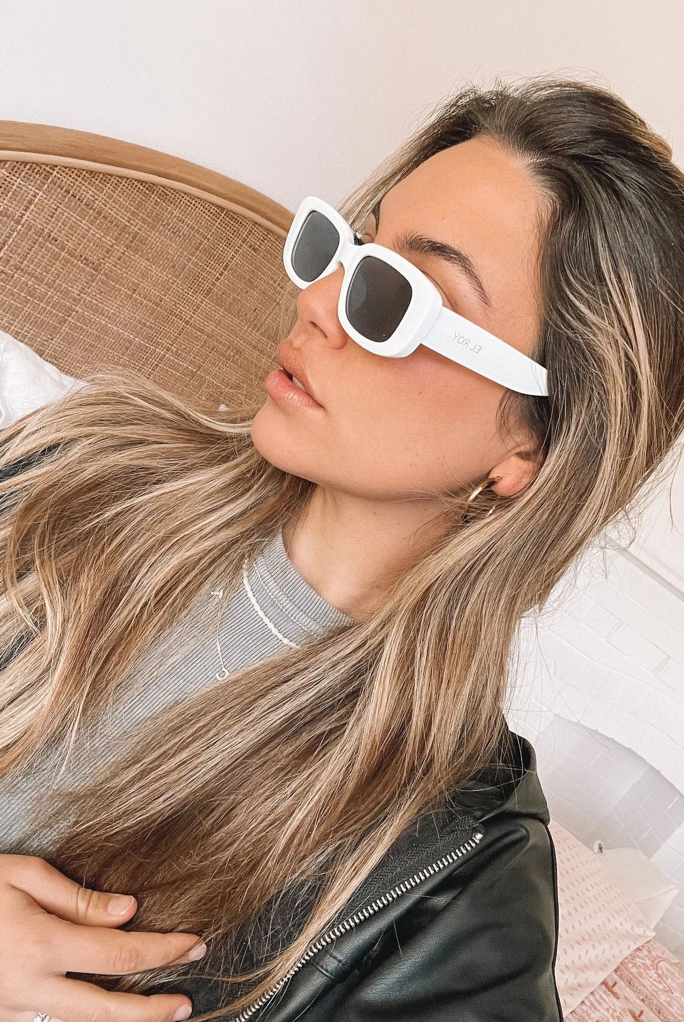 A pair of white-framed sunglasses displayed against a neutral background.