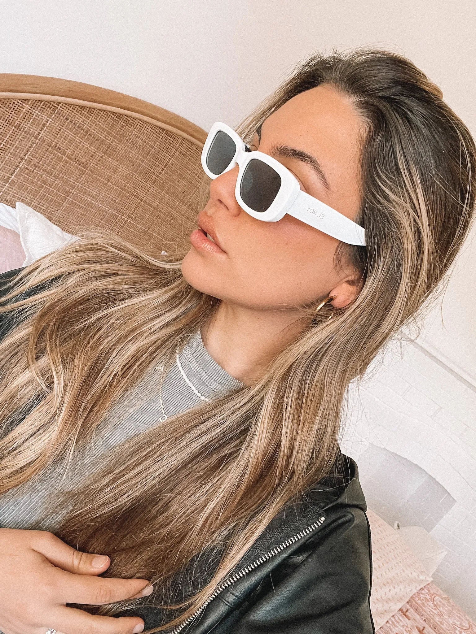 A pair of white-framed sunglasses displayed against a neutral background.