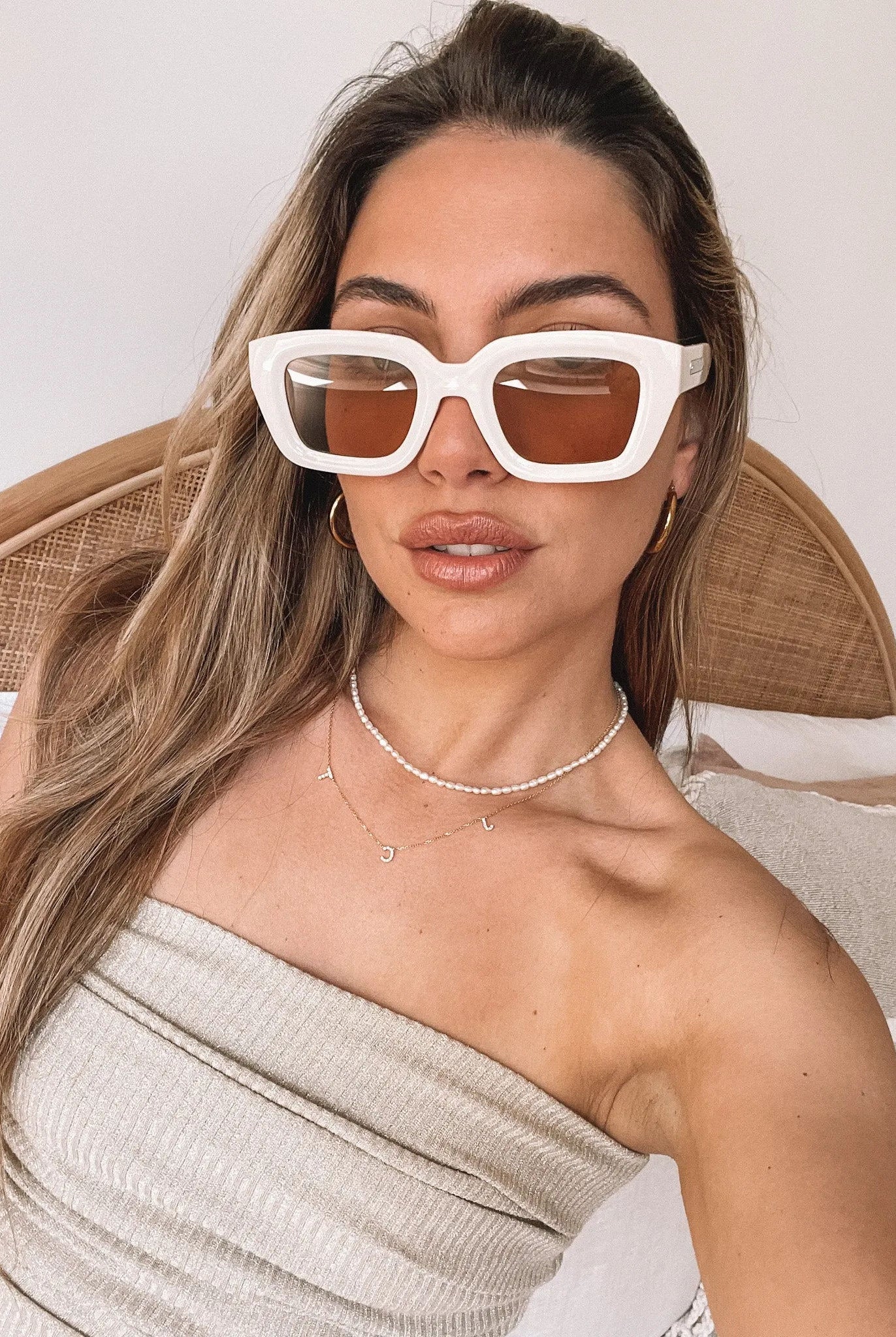 A pair of beige sunglasses displayed on a surface.