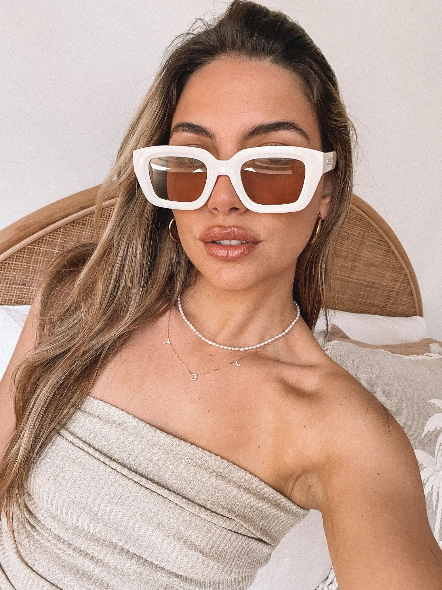 A pair of beige sunglasses displayed on a surface.