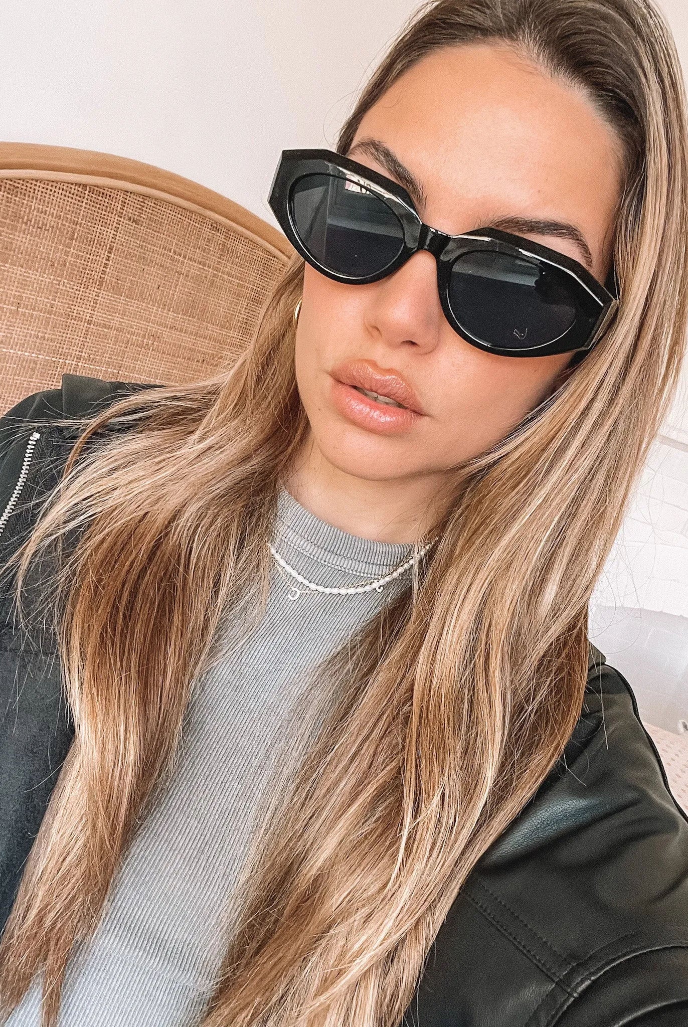 A pair of black sunglasses displayed against a neutral background.