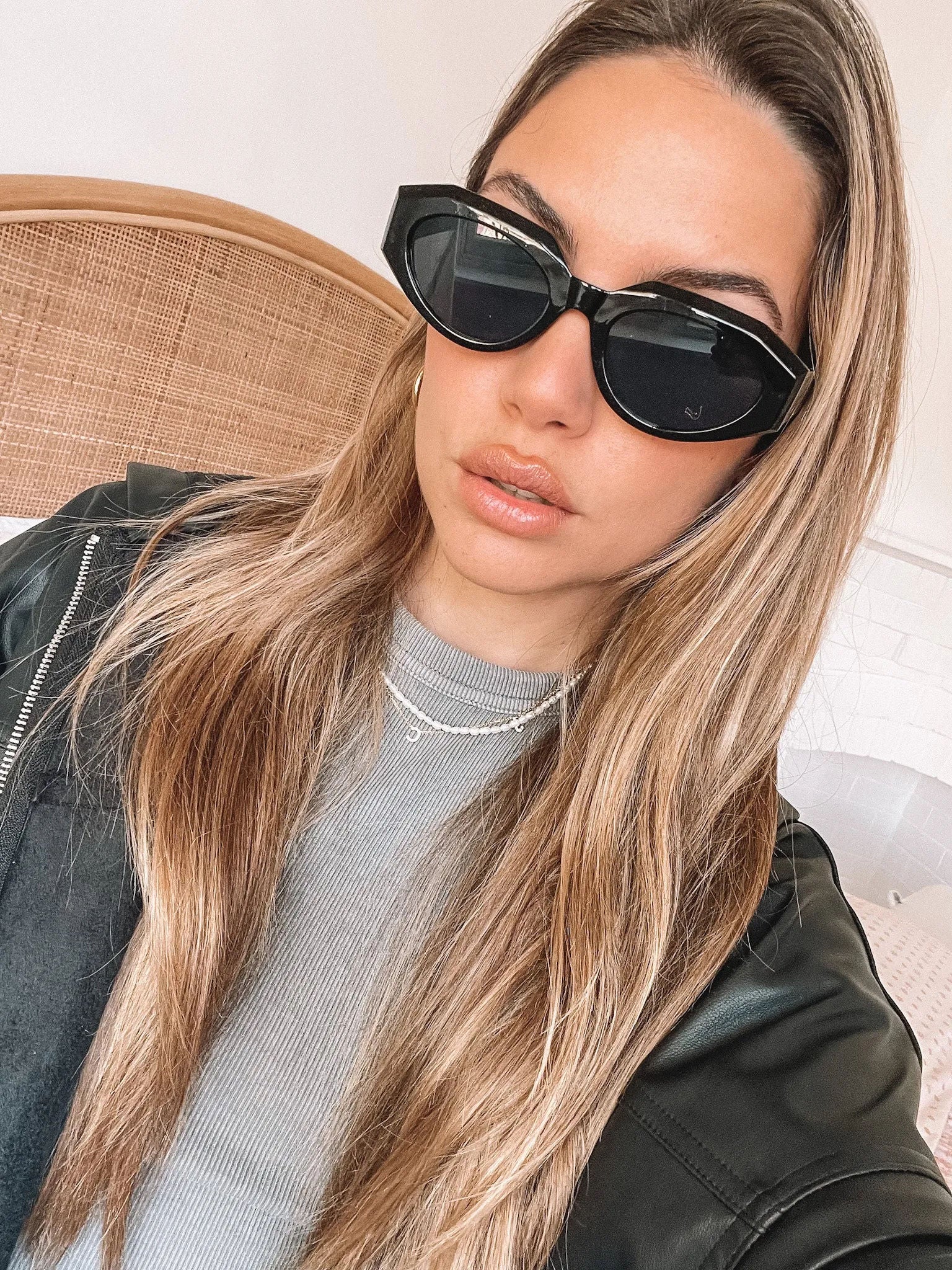 A pair of black sunglasses displayed against a neutral background.