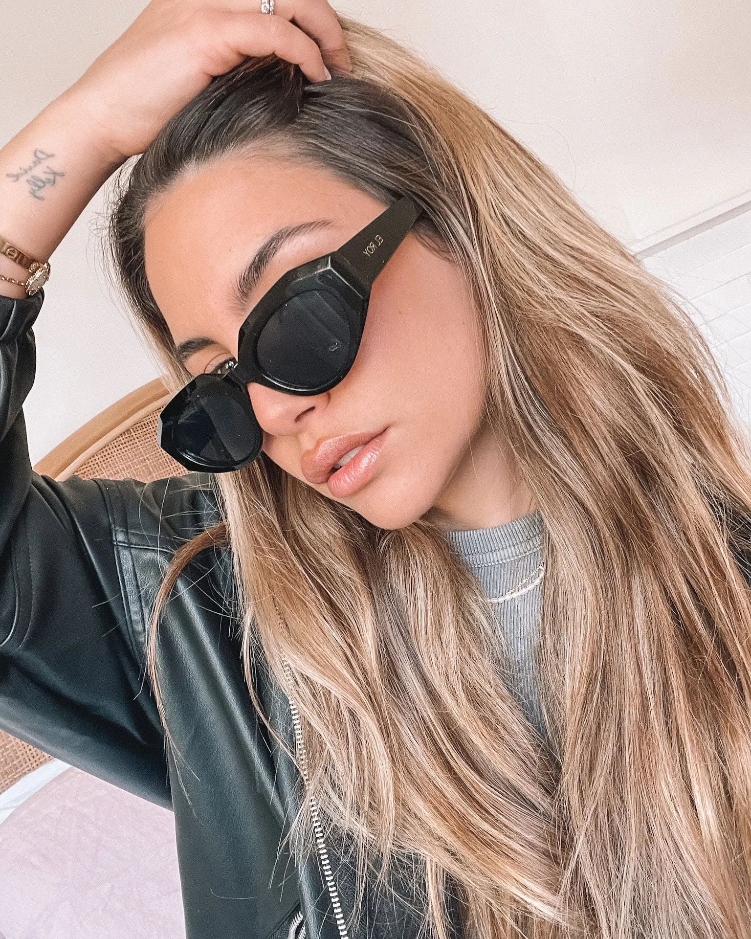 A pair of black sunglasses displayed against a neutral background.