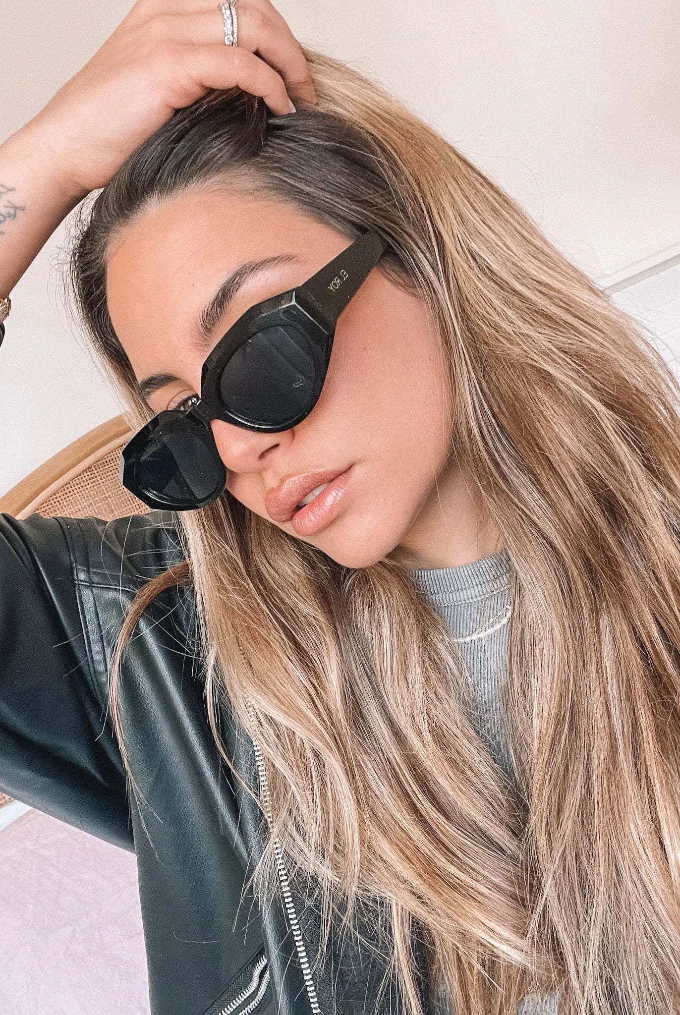 A pair of black sunglasses displayed against a neutral background.