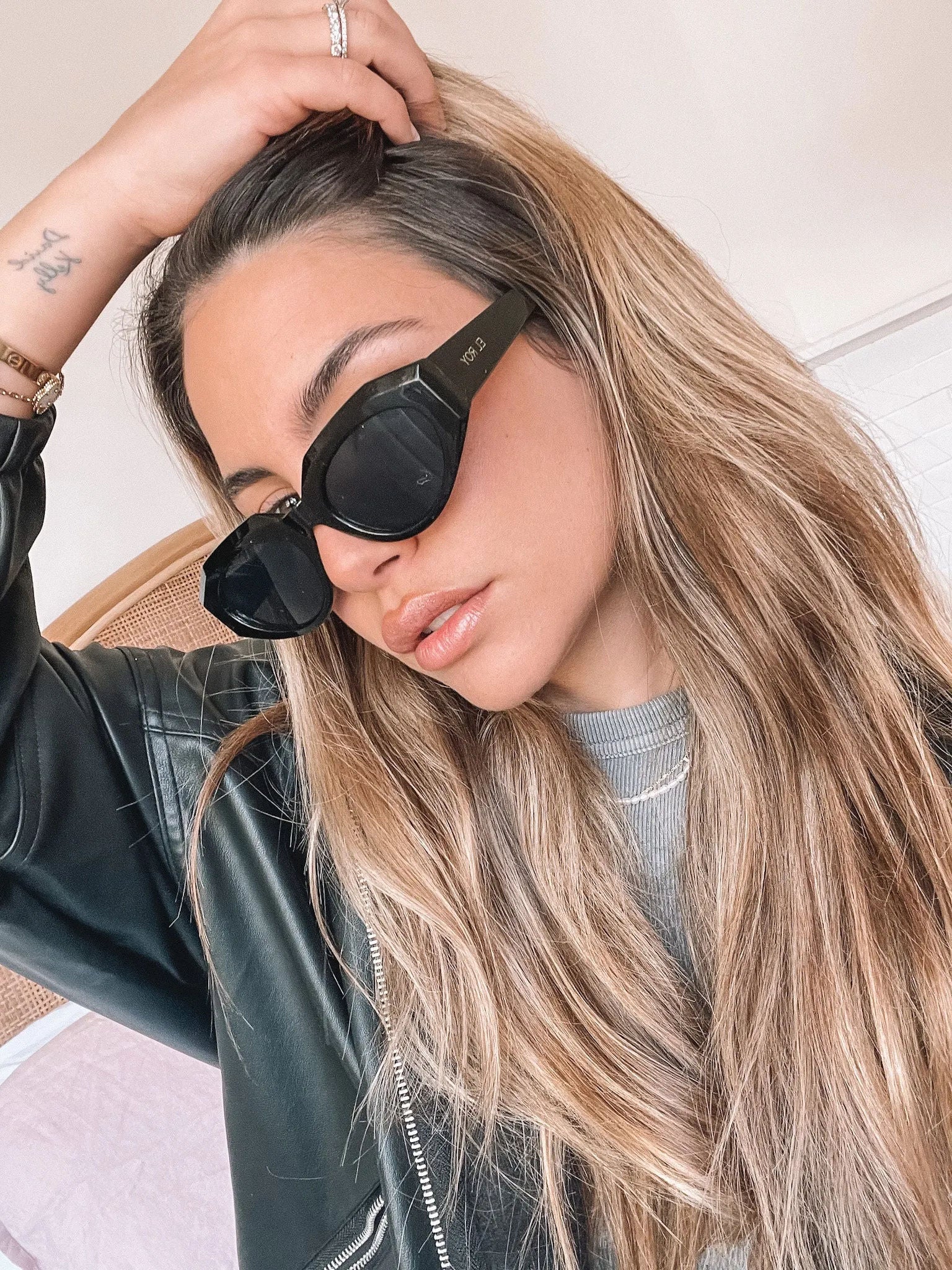 A pair of black sunglasses displayed against a neutral background.