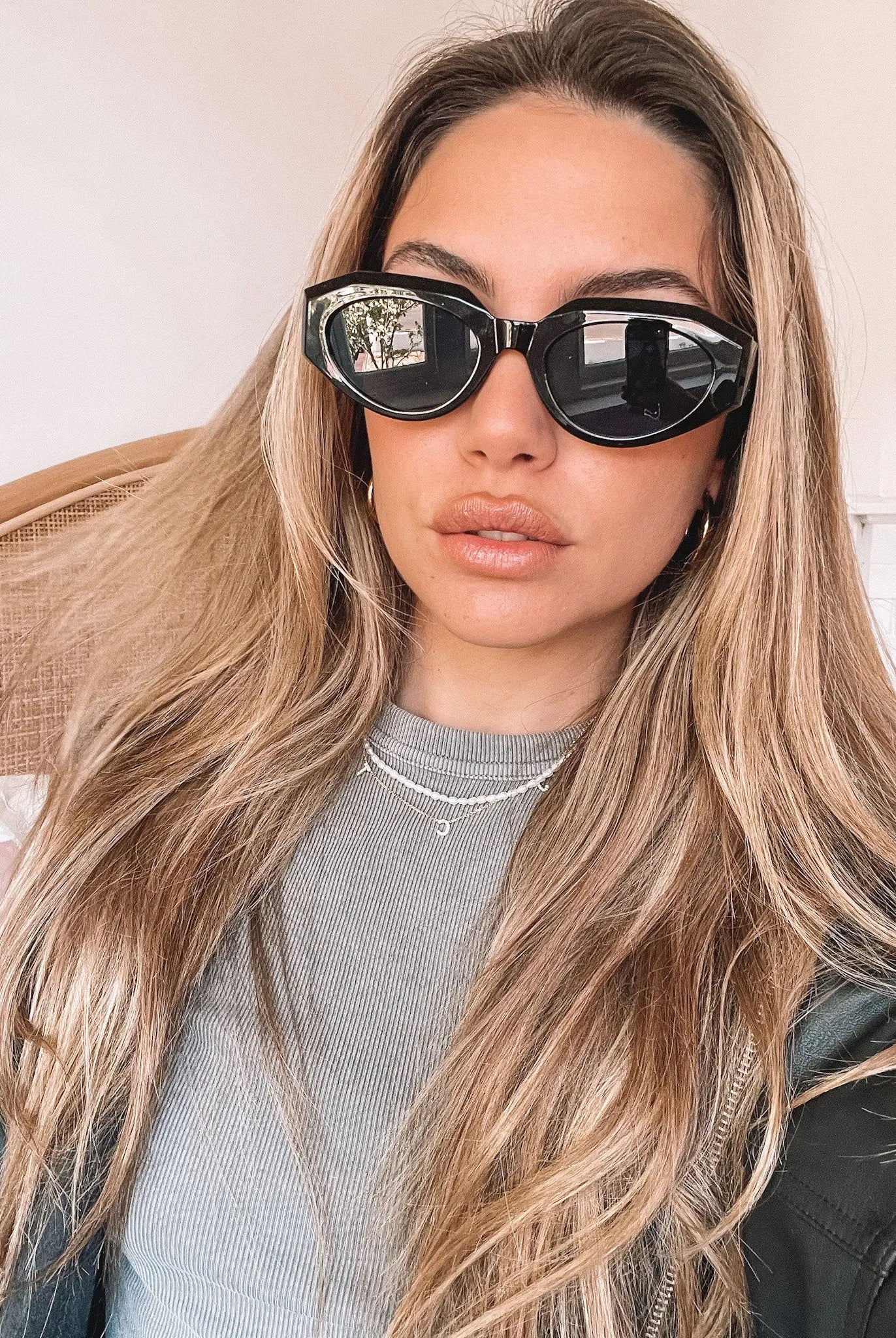 A pair of black sunglasses displayed against a neutral background.