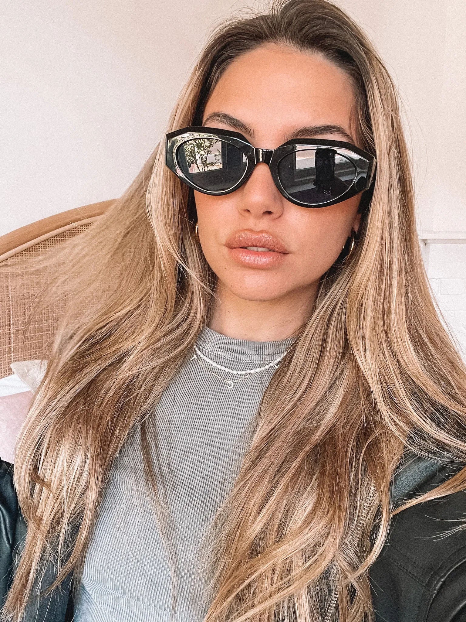 A pair of black sunglasses displayed against a neutral background.
