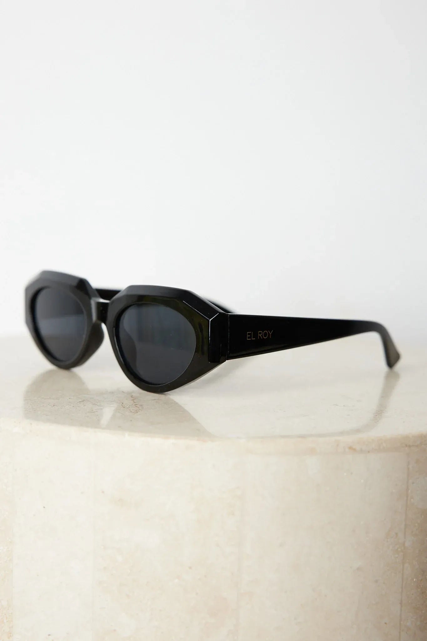 A pair of black sunglasses displayed against a neutral background.