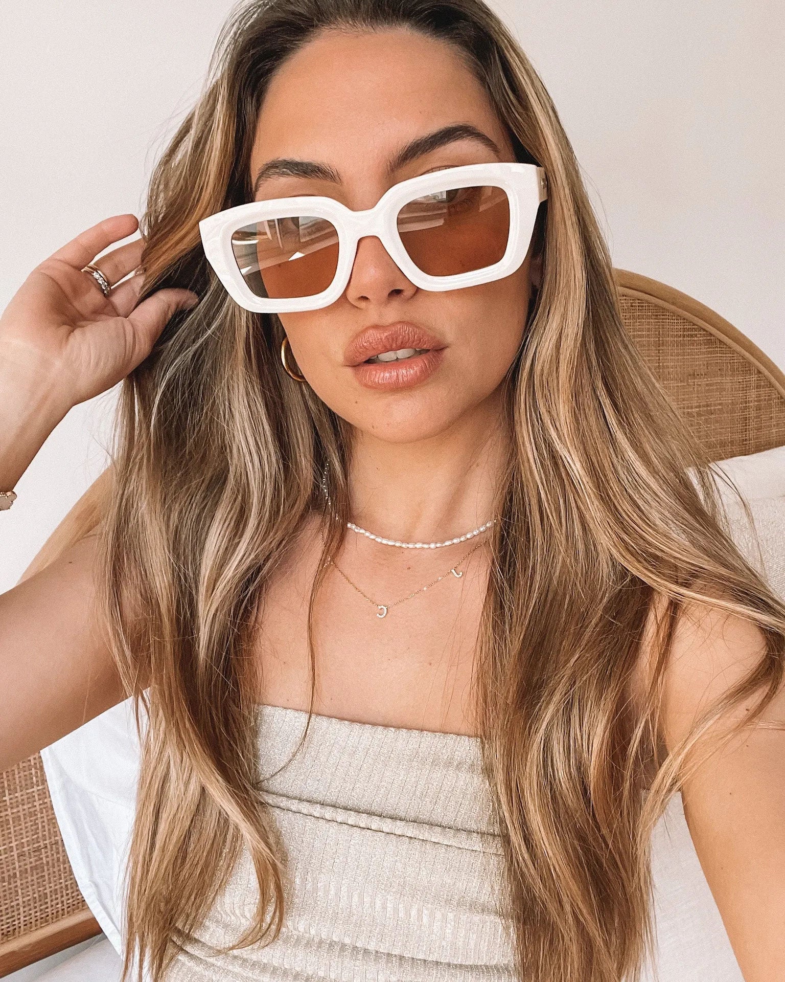 A pair of beige sunglasses displayed on a surface.