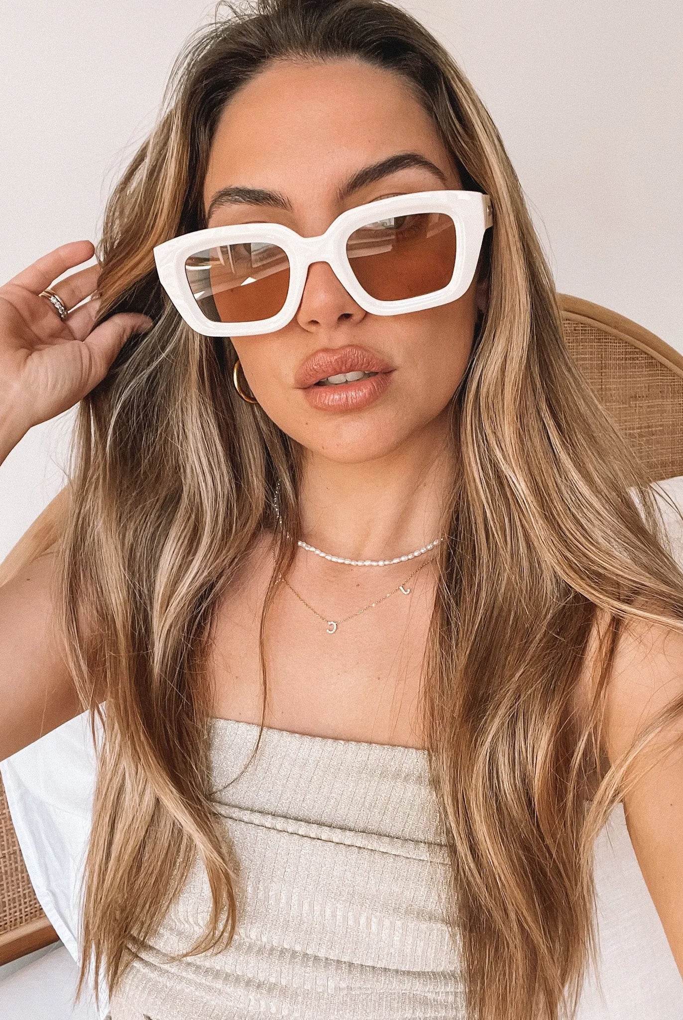 A pair of beige sunglasses displayed on a surface.